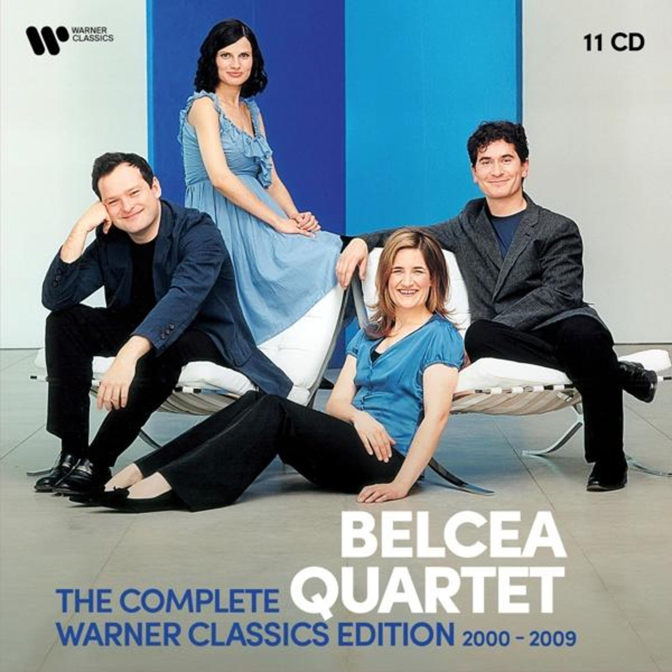 Quattro musicisti seduti su sedie moderne davanti a uno sfondo blu. Warner Classics.