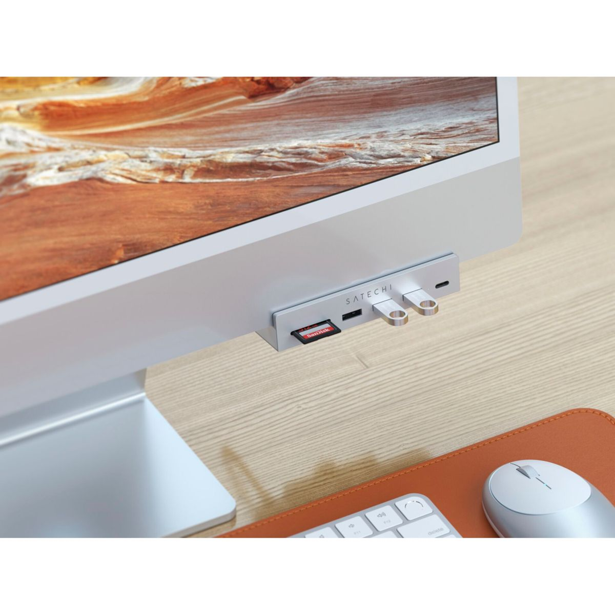 Un hub Satechi con scheda SD e unità USB è collegato a un computer argentato.