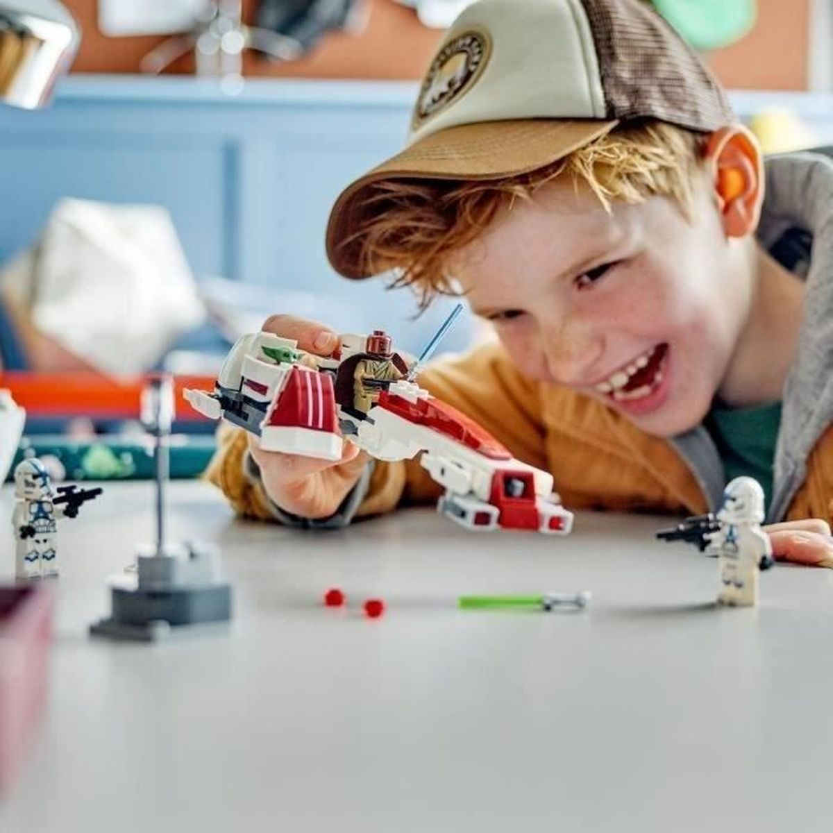 Chłopiec bawi się statkiem kosmicznym Lego i figurkami w jasnym pokoju.