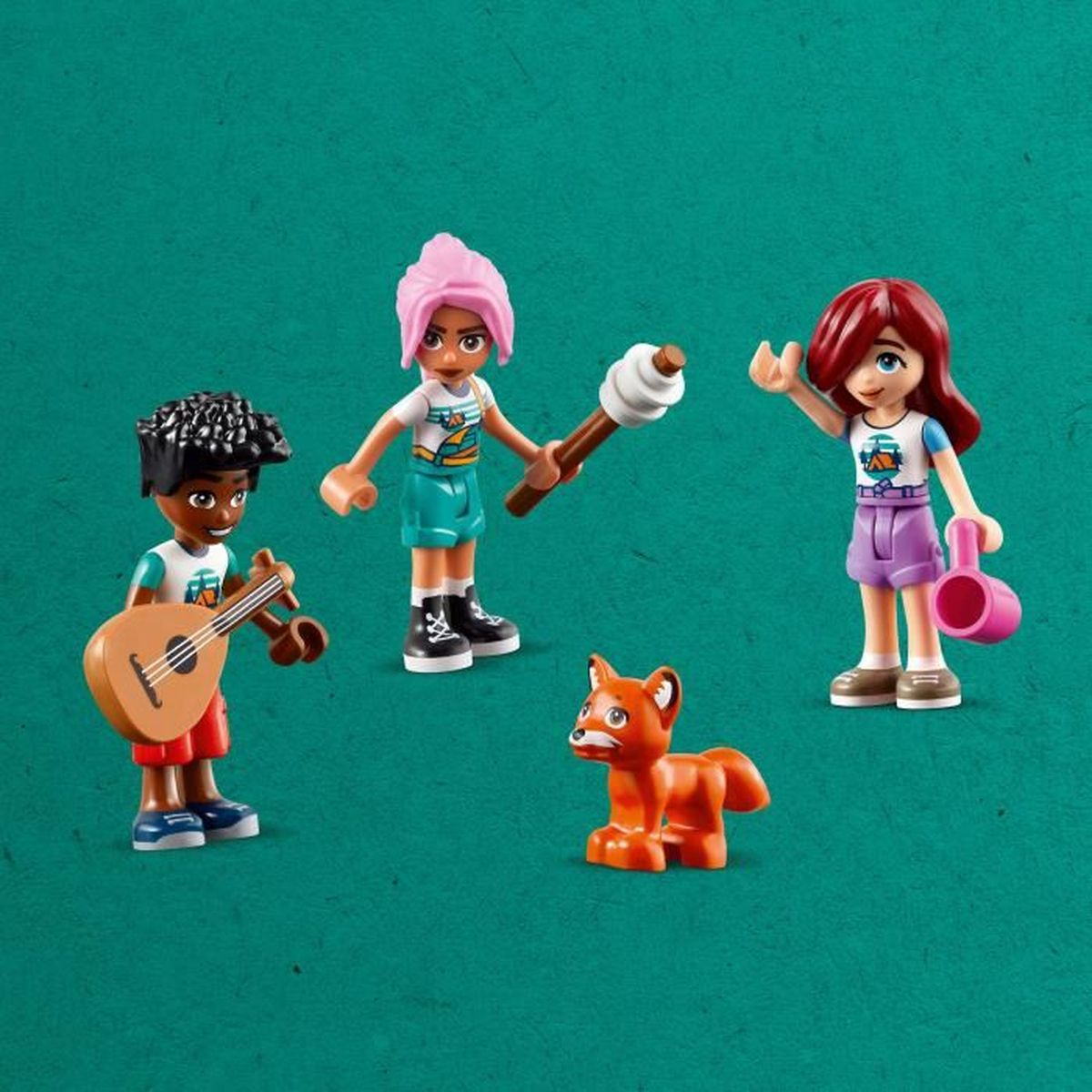 Trzy figurki LEGO Friends i zabawka lisa na zielonym tle.
