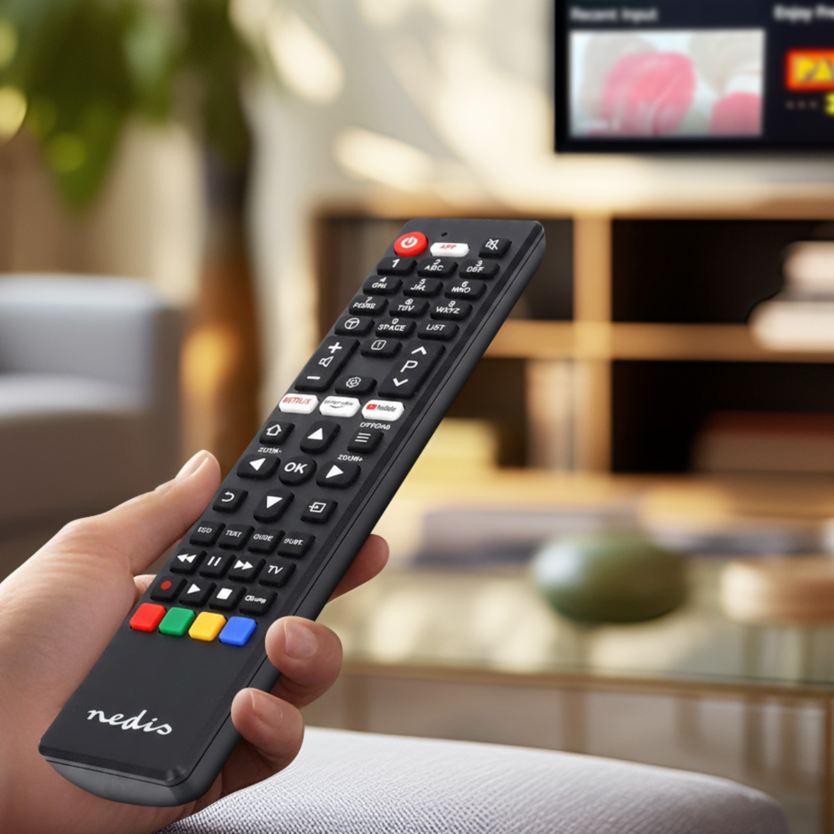 Dłoń trzyma czarny pilot z przyciskami Netflix i YouTube.