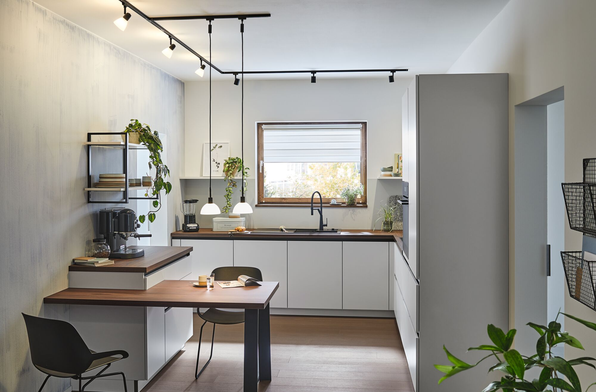 Moderne Küche mit Holzboden, weißer Einbauküche, Holztheke und Esstisch.