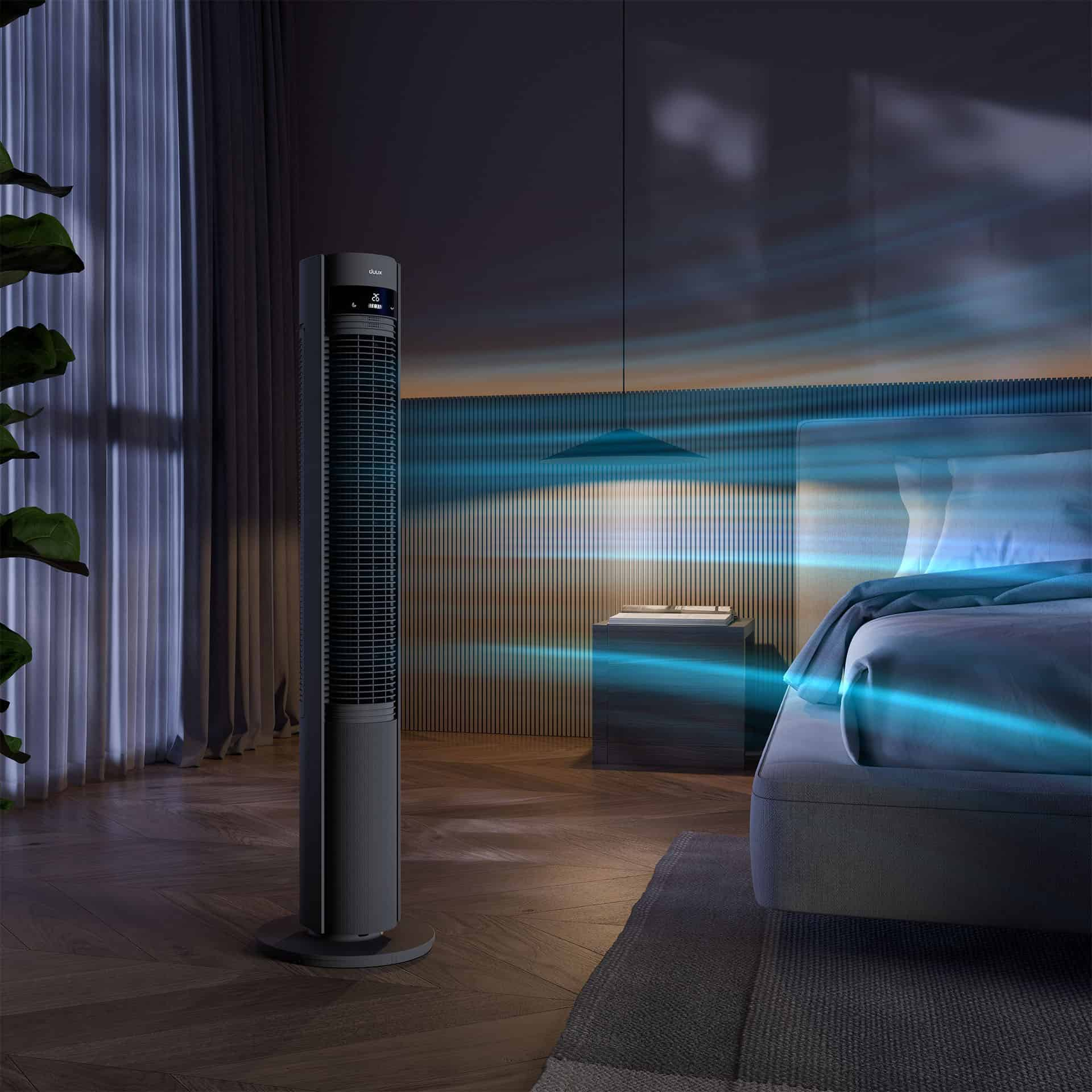 Ein schlanker Turmventilator zirkuliert kühle blaue Luft in einem modernen Schlafzimmer.