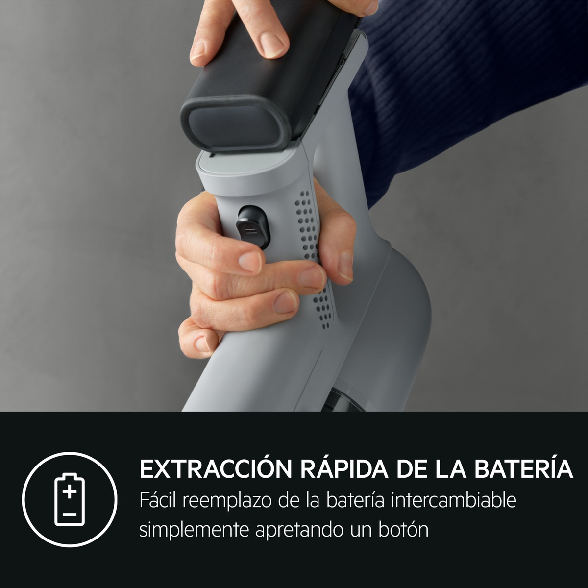 Una mano extrae una batería negra de un dispositivo gris.