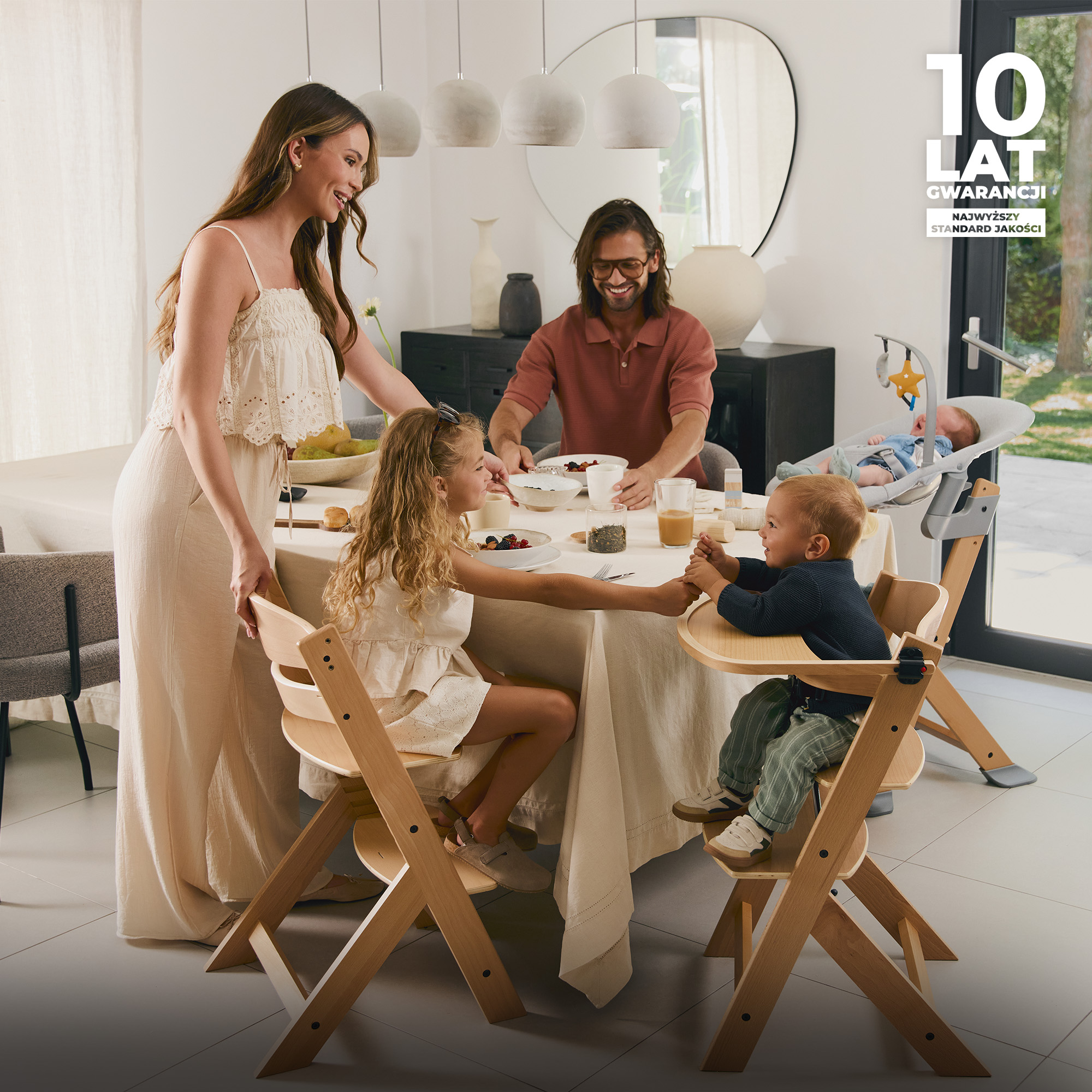 Familie am Tisch: Mutter, Vater, zwei Kinder, ein Baby im Hochstuhl.