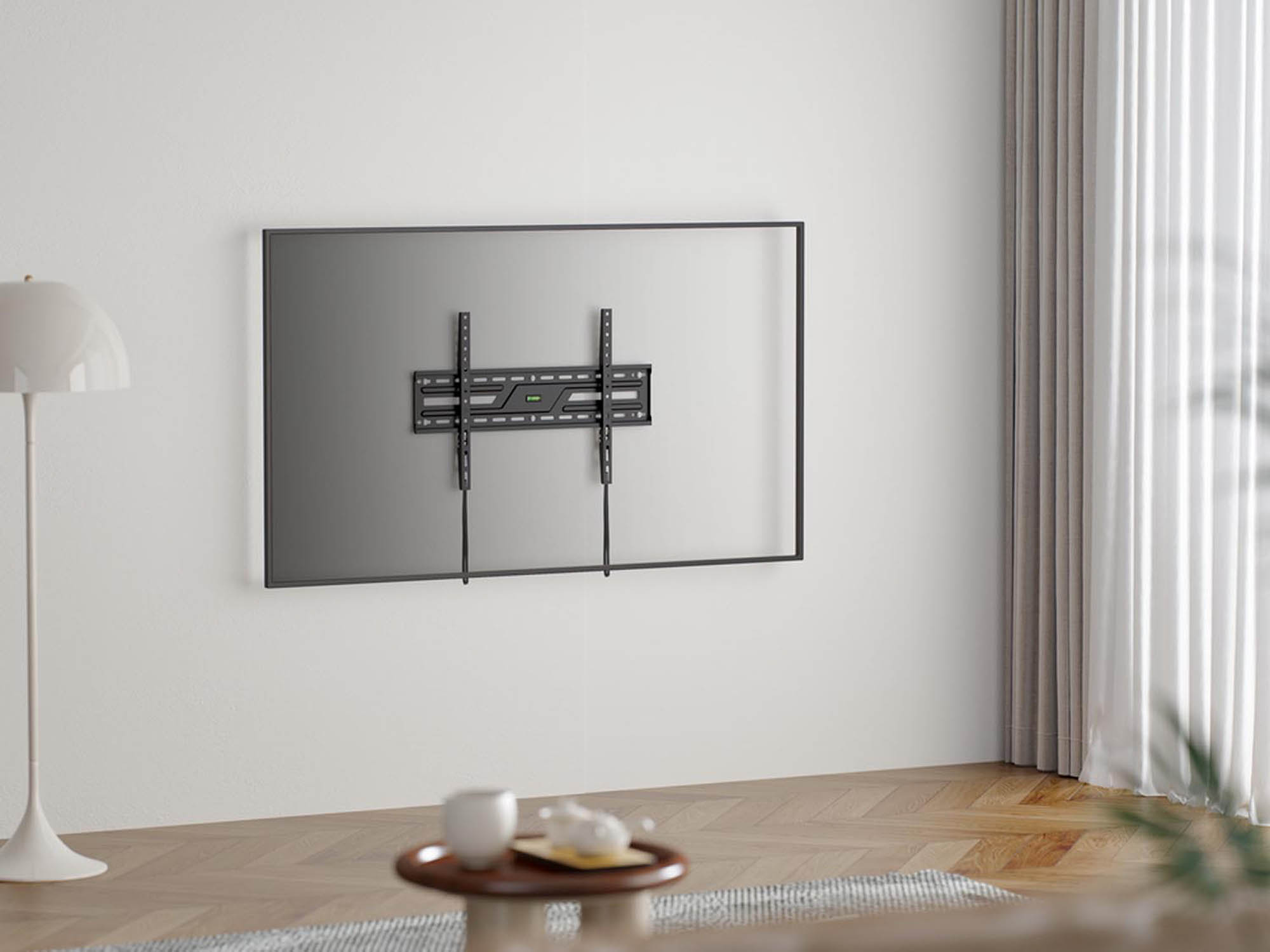 Een zwarte tv aan een witte muur met beugel. Lamp ernaast.
