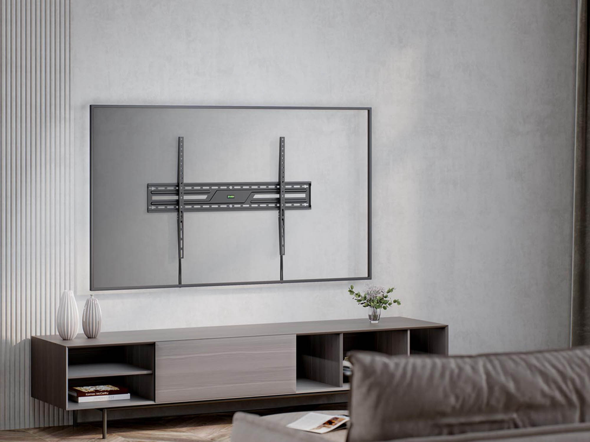 Une grande télévision avec support mural au-dessus d'un meuble bas décoré.