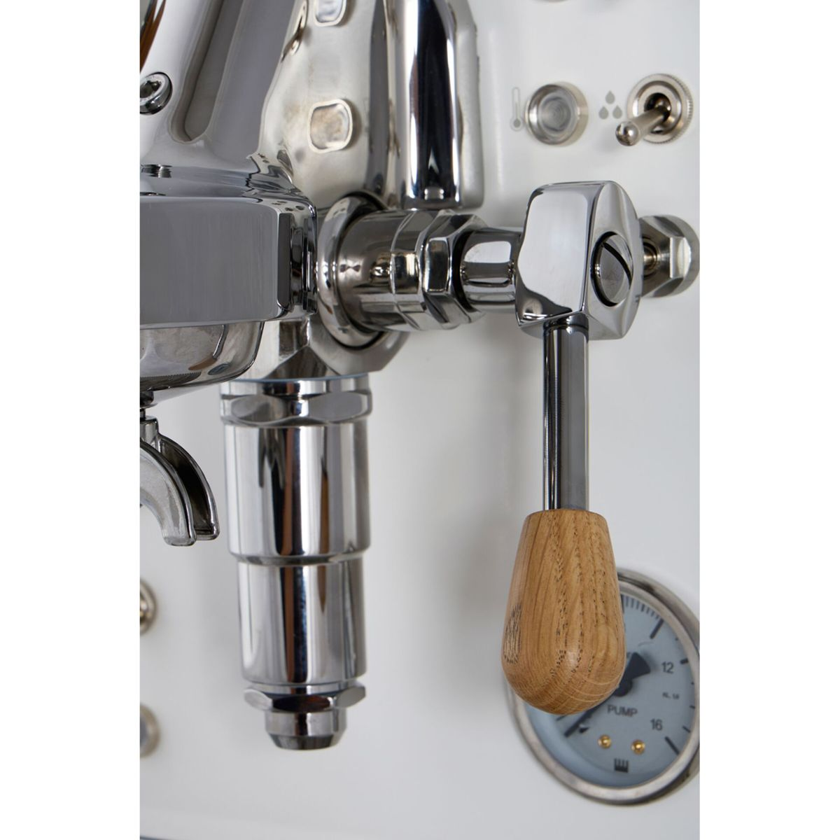 Detail einer Espressomaschine mit Chromhebel, Holzgriff und Druckanzeige.