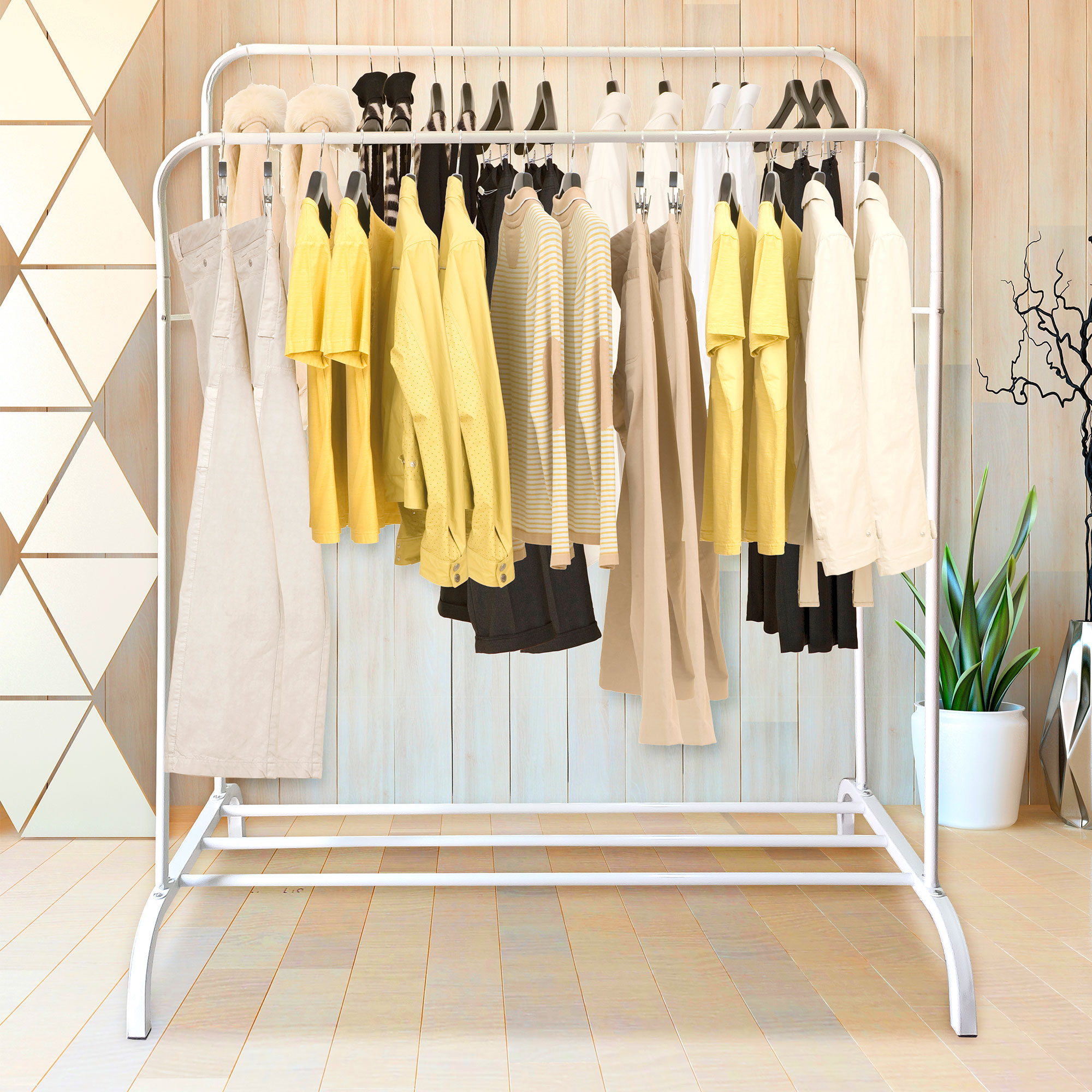 Perchero con ropa amarilla, pantalones y suéteres en primer plano.