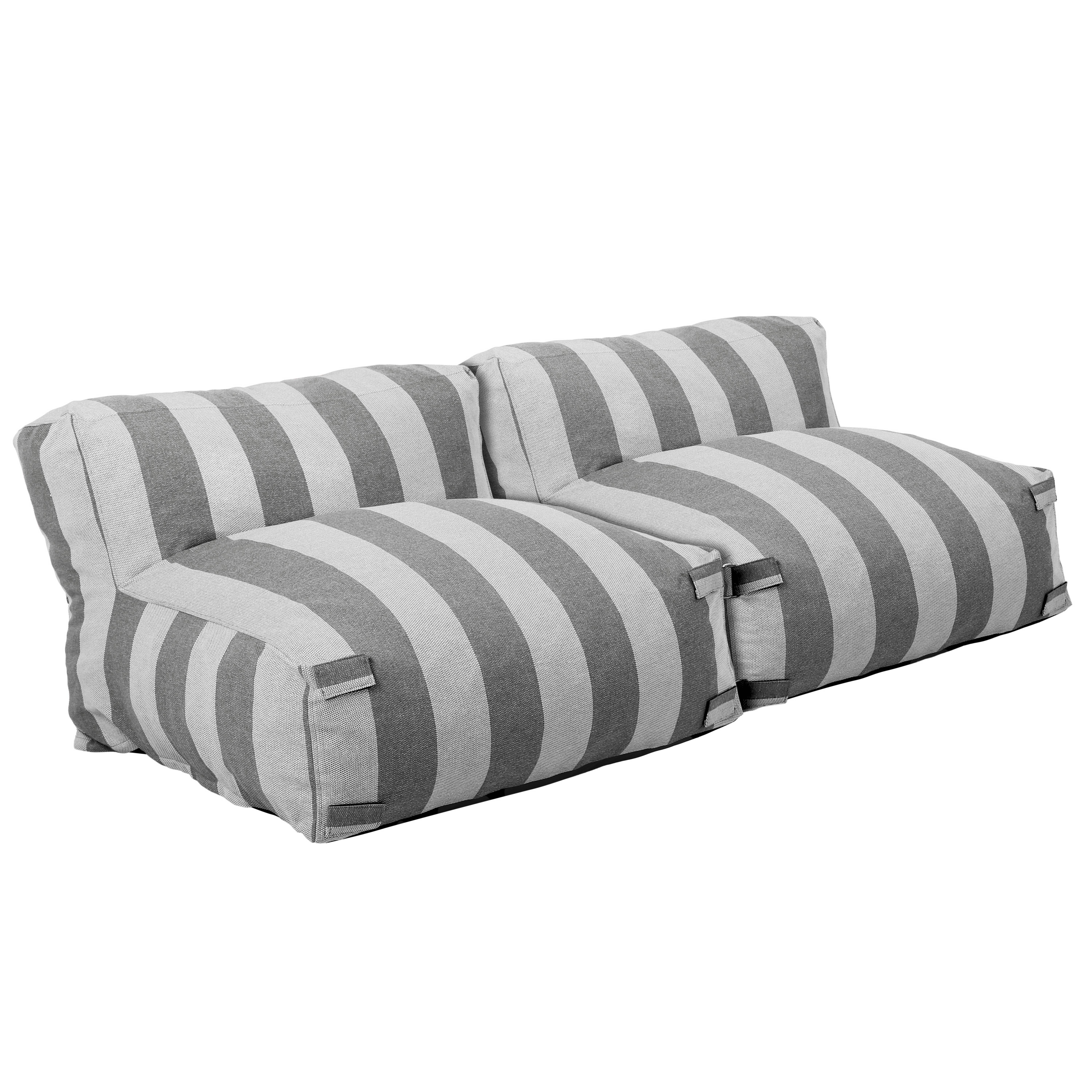 Ein gestreiftes Sofa mit grauen und weißen Streifen, freigestellt.