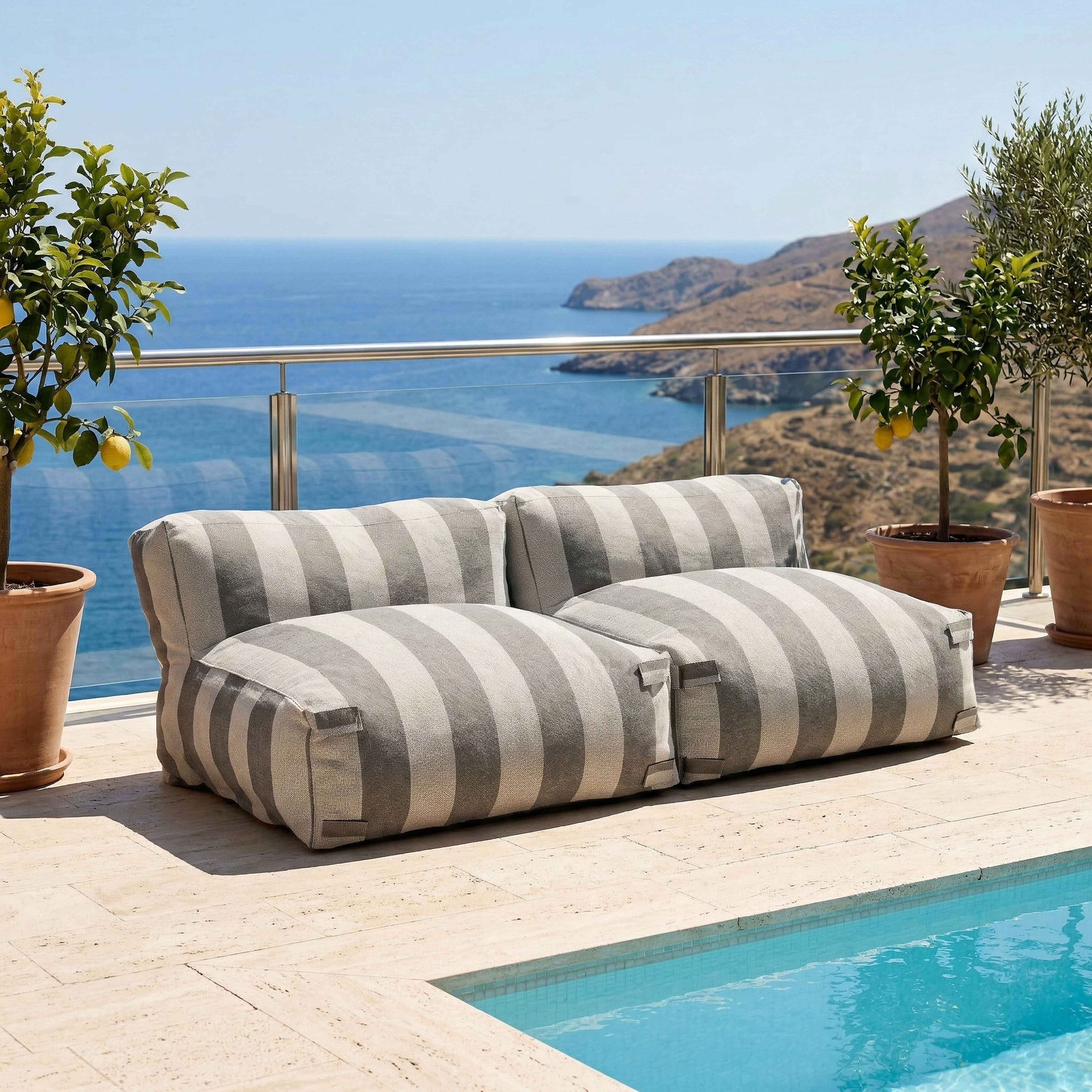 Gestreifte Outdoor-Möbel am Pool mit Meerblick.