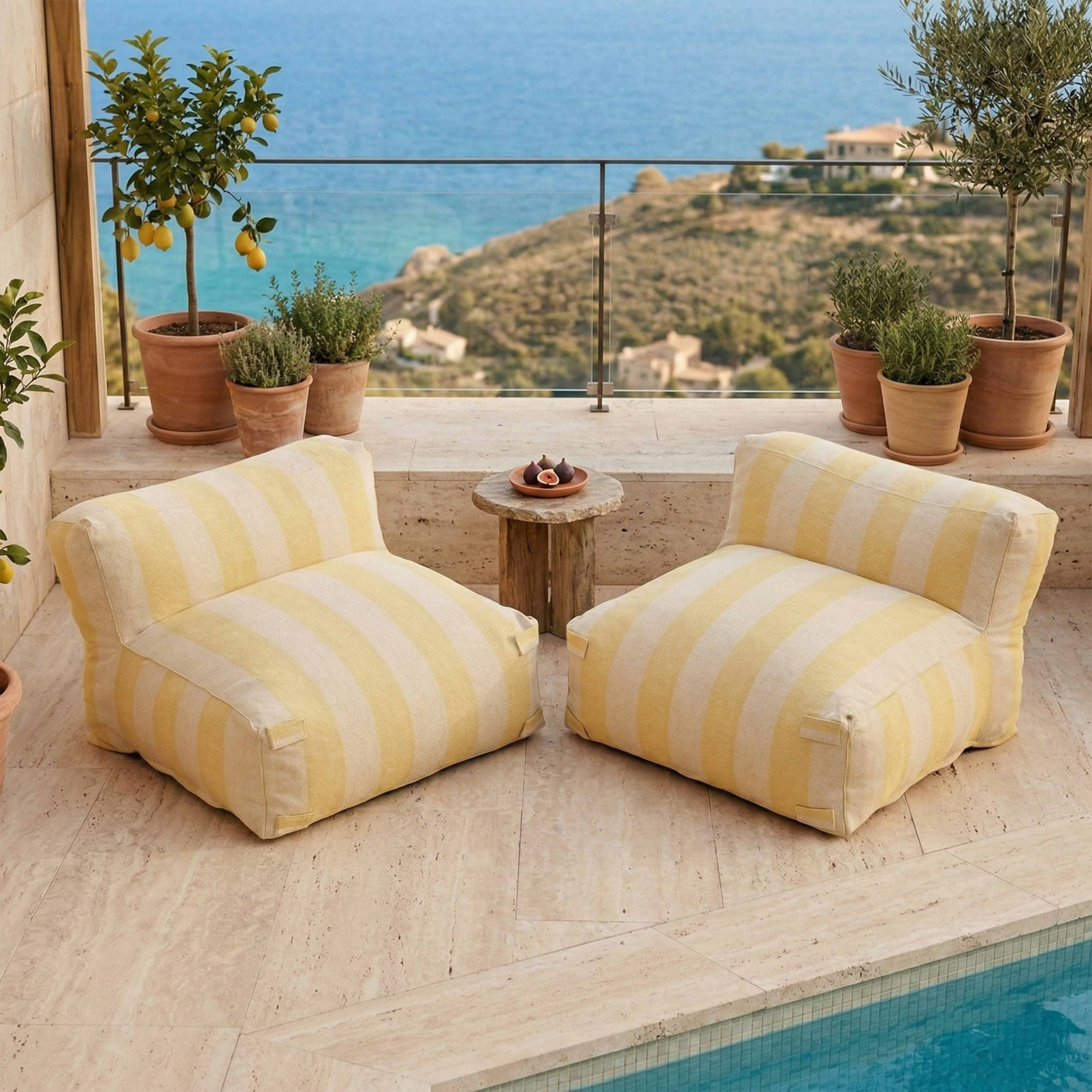 Zwei gestreifte Poufs am Pool mit Meerblick und Zitronenbaum.