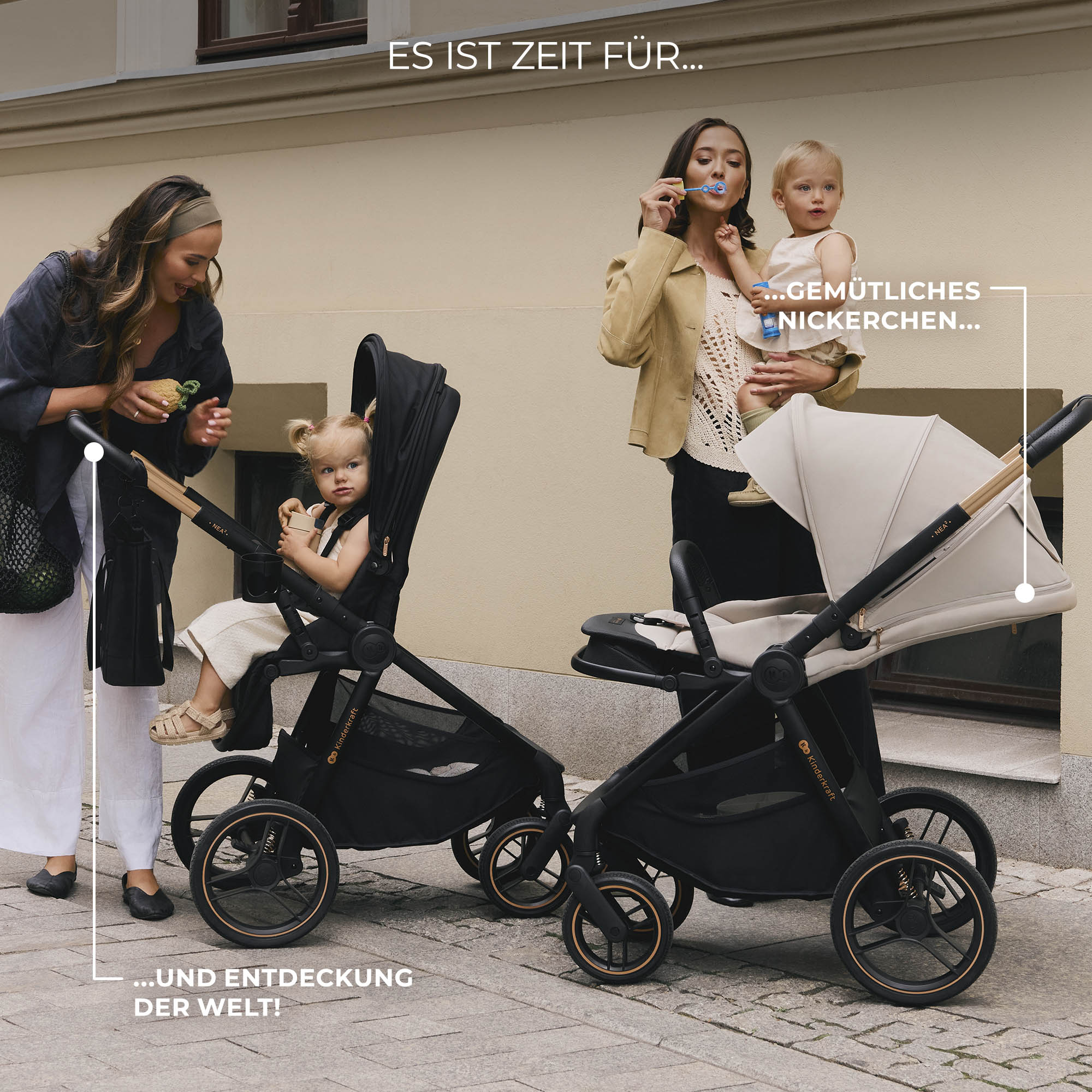 Zwei Frauen mit Kindern in Kinderwagen vor einer Wand.