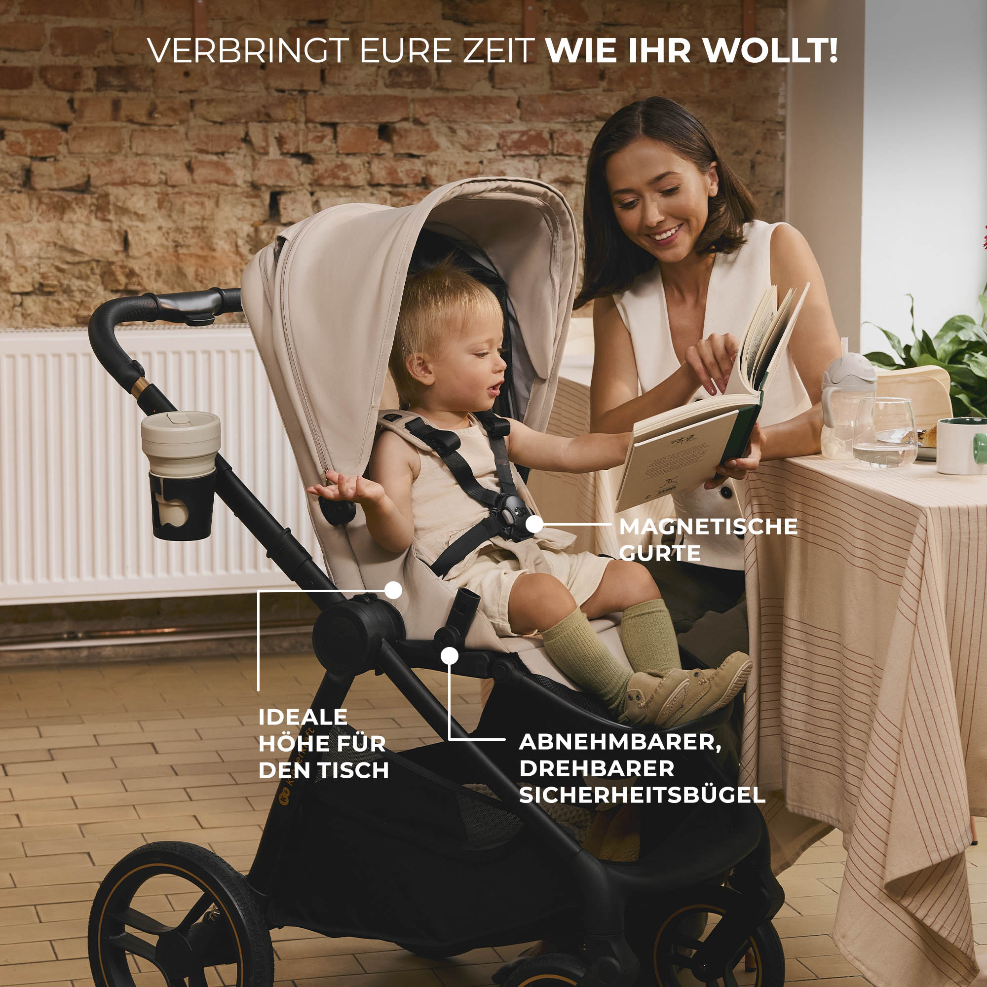 Eine Frau liest einem Baby im Kinderwagen vor. Sie sitzen an einem Tisch.