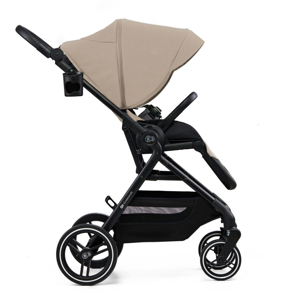 Ein beiger Kinderwagen mit schwarzem Rahmen und Rädern, von der Seite gezeigt.