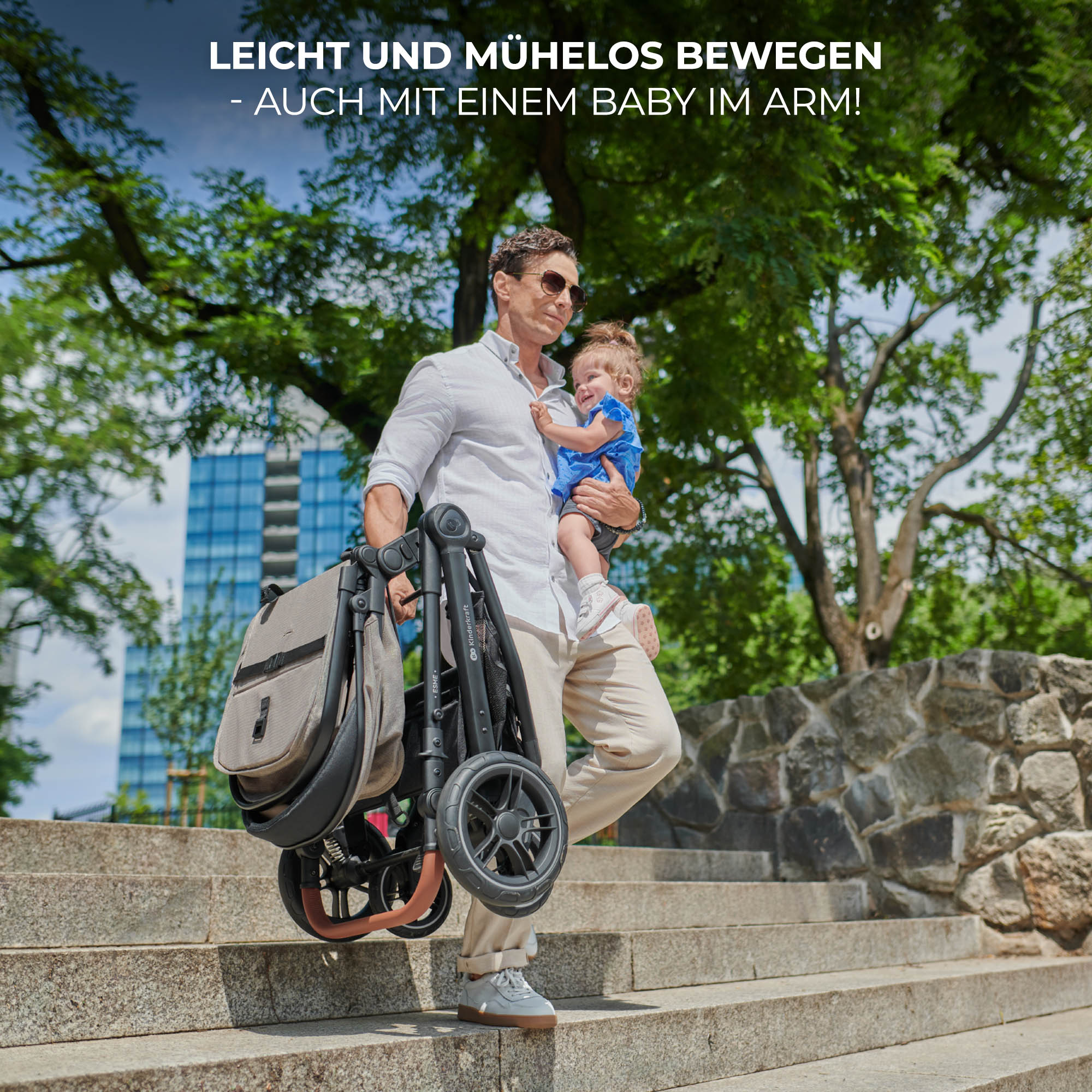 Ein Mann trägt ein Baby und einen Kinderwagen auf einer Treppe.