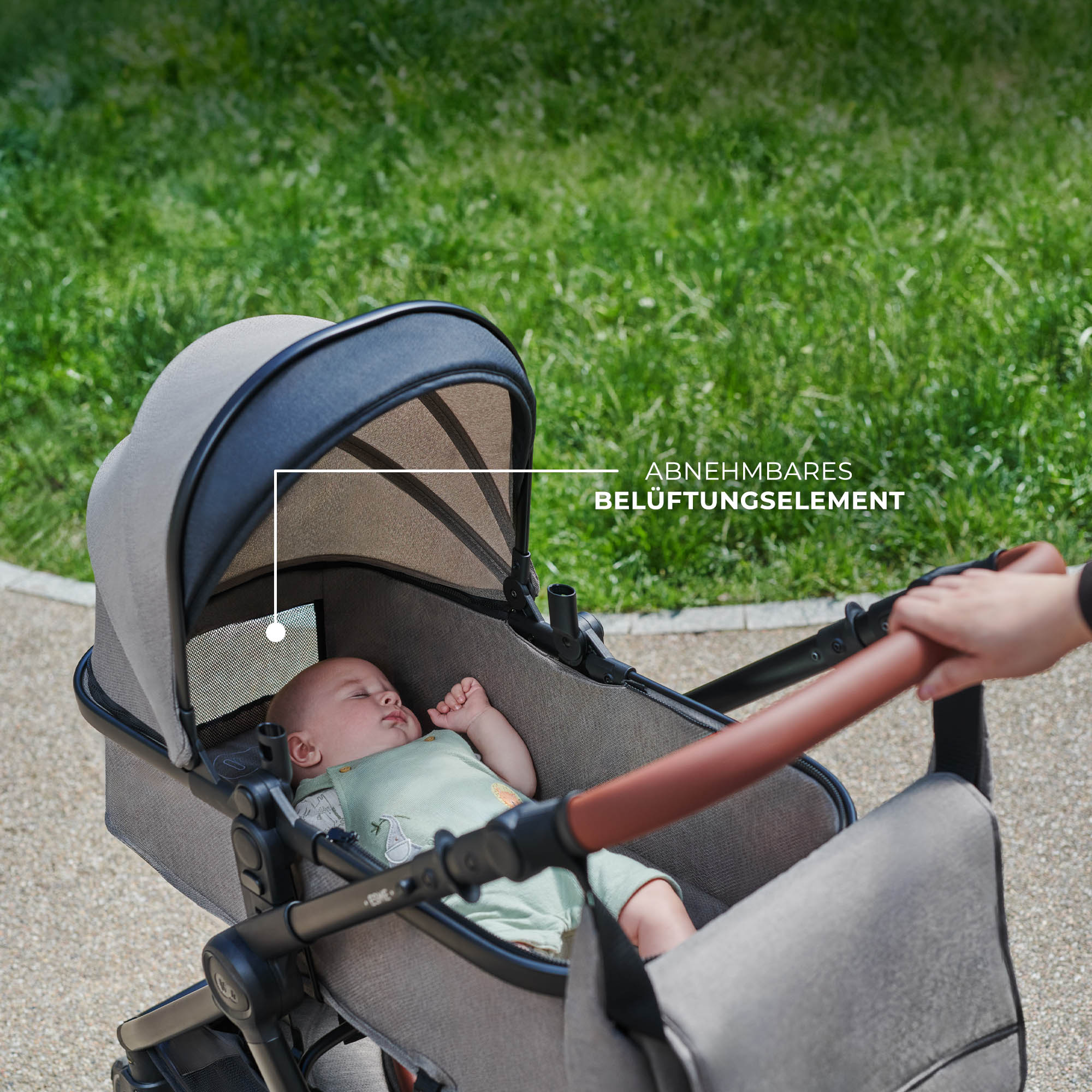 Ein Baby schläft in einem Kinderwagen draußen auf einem Weg.