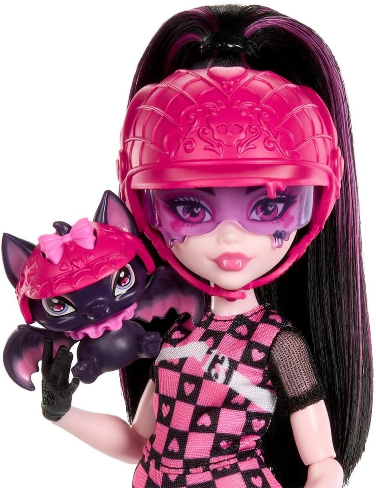 Una muñeca con una pequeña mascota murciélago, ambas con cascos rosas.