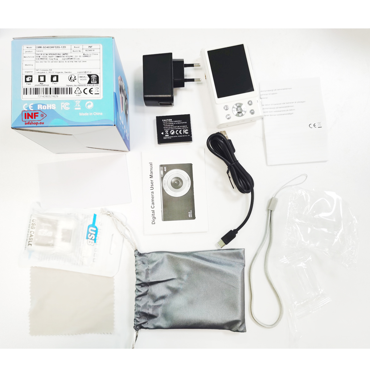 Biały zestaw aparatu cyfrowego z akcesoriami: ładowarka, bateria, kabel, instrukcja.