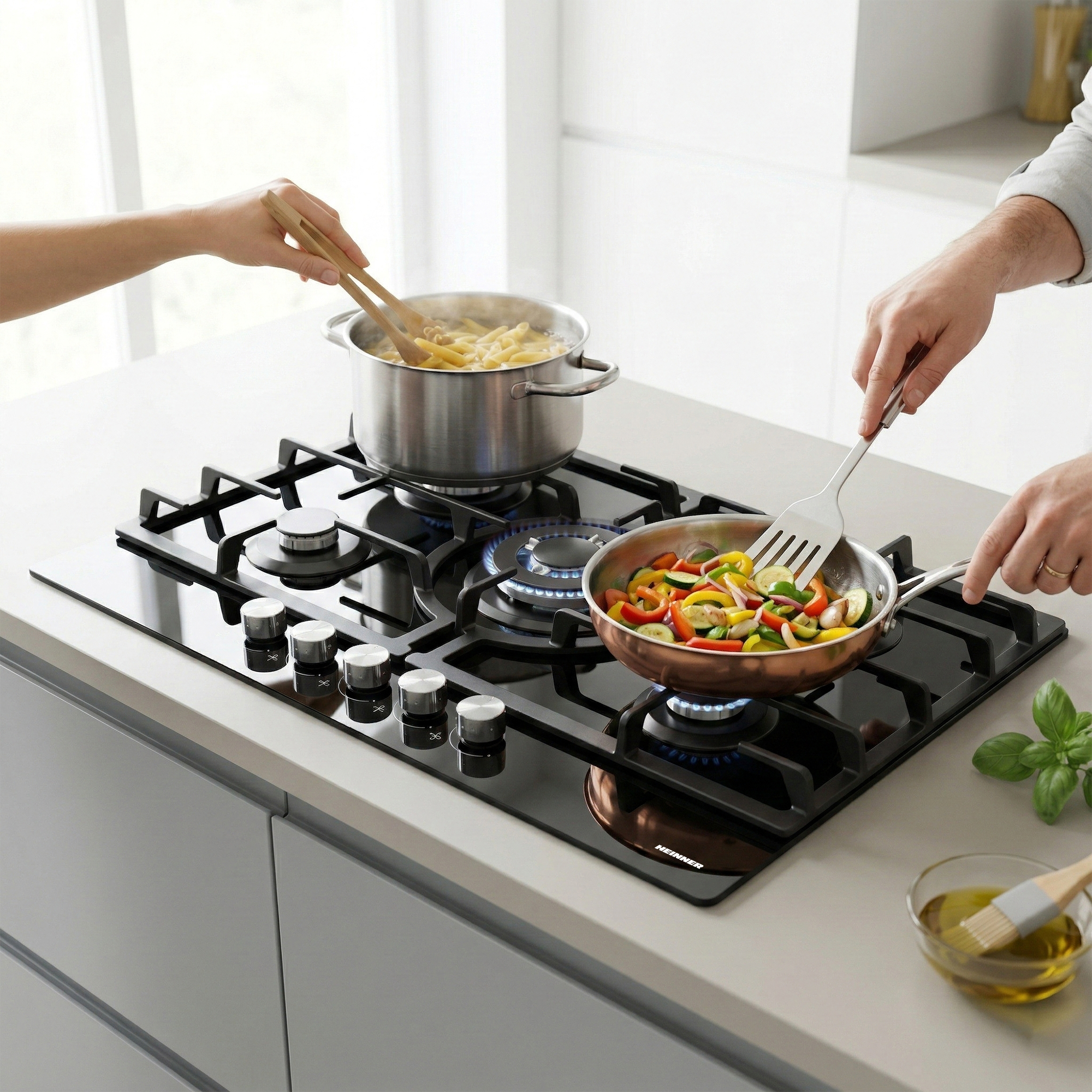 Zwei Hände kochen auf einem Gasherd: Pasta in einem Topf, Gemüse in einer Pfanne.