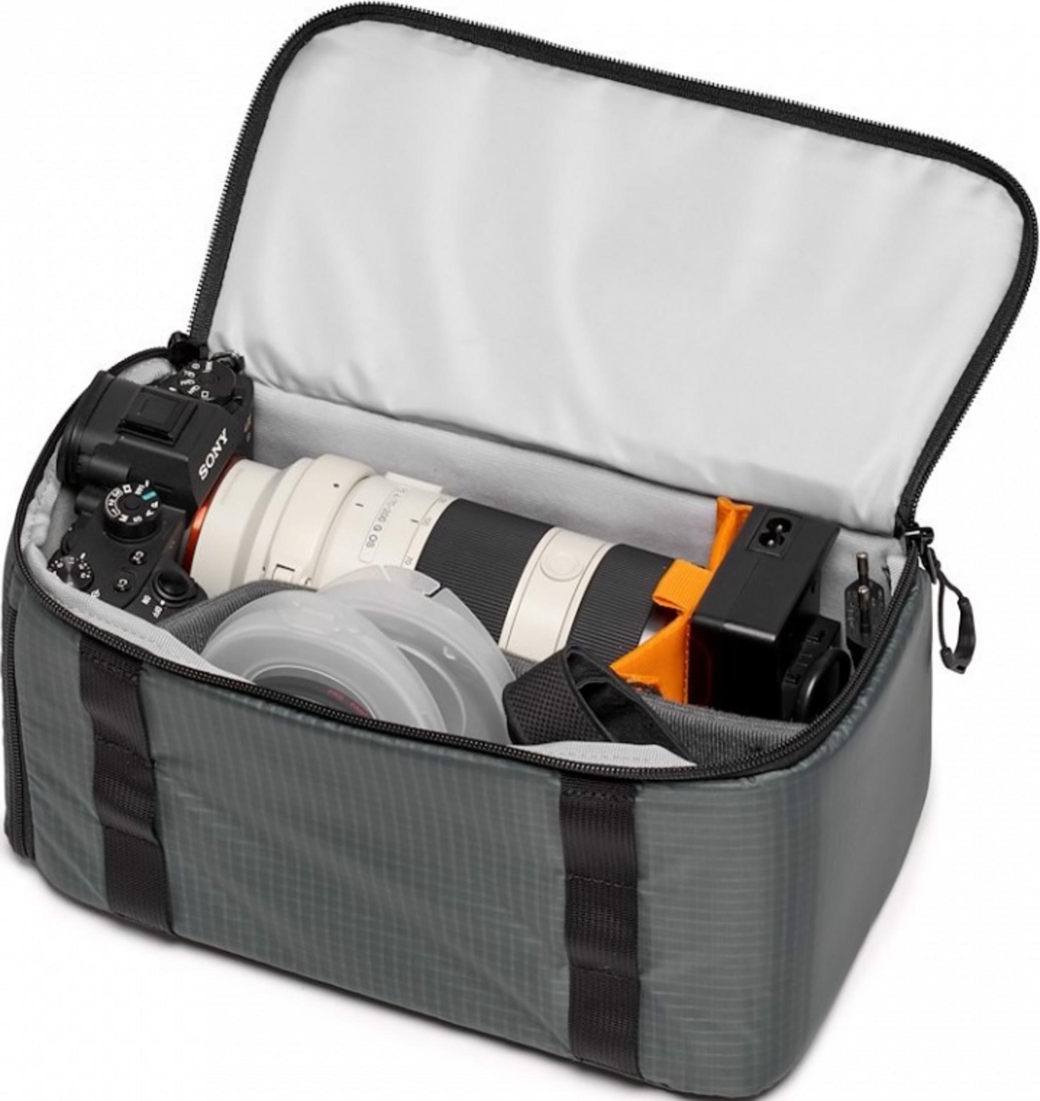 Gray camera bag with Sony camera, lens, battery, and cables inside.