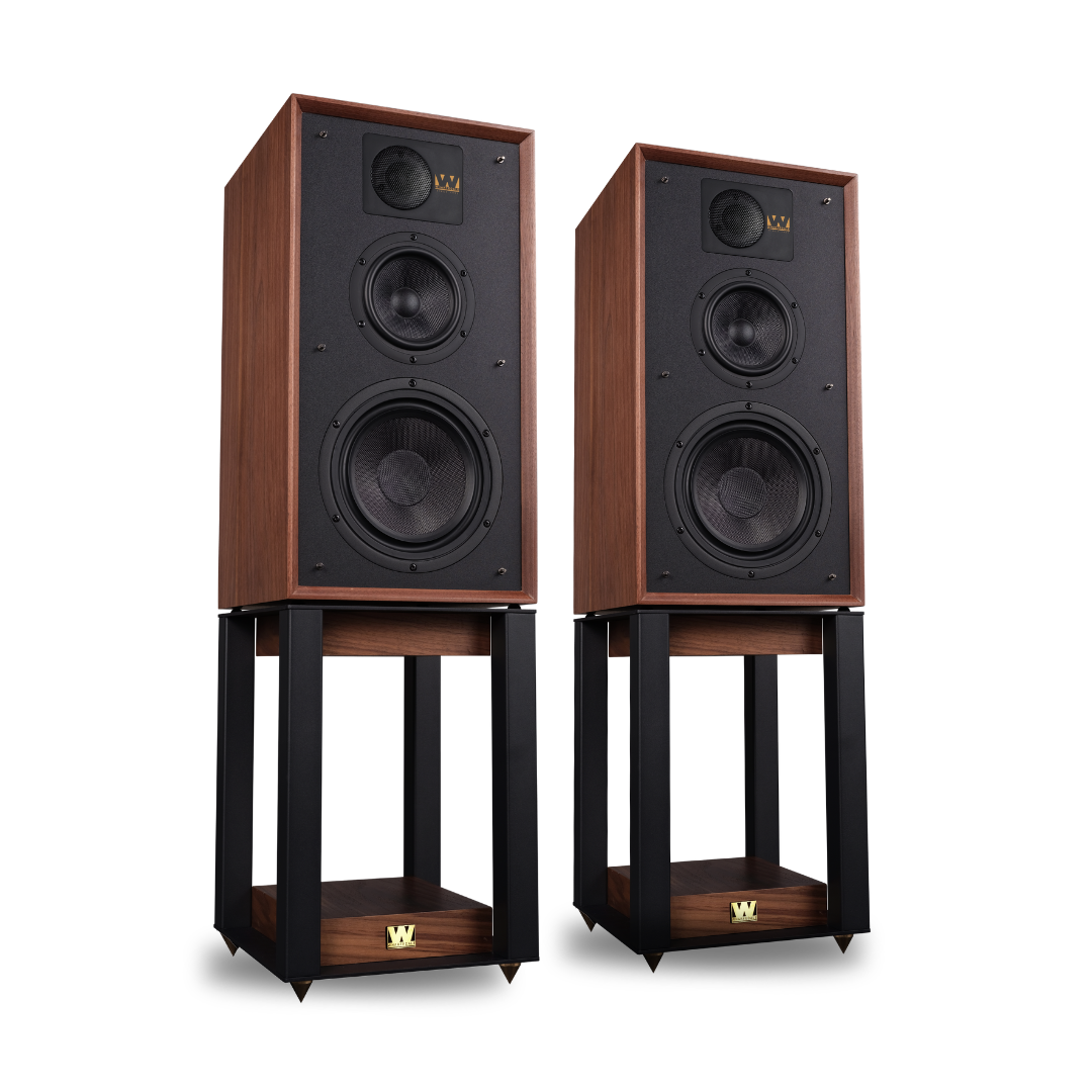 Twee bruine luidsprekers op zwarte standaards met houten bases en gouden logo's.