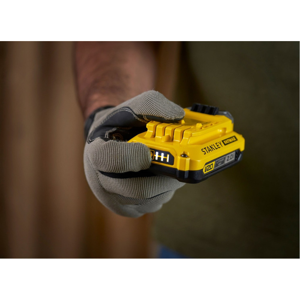 Ręka w rękawicy trzyma żółtą baterię Stanley Fatmax.