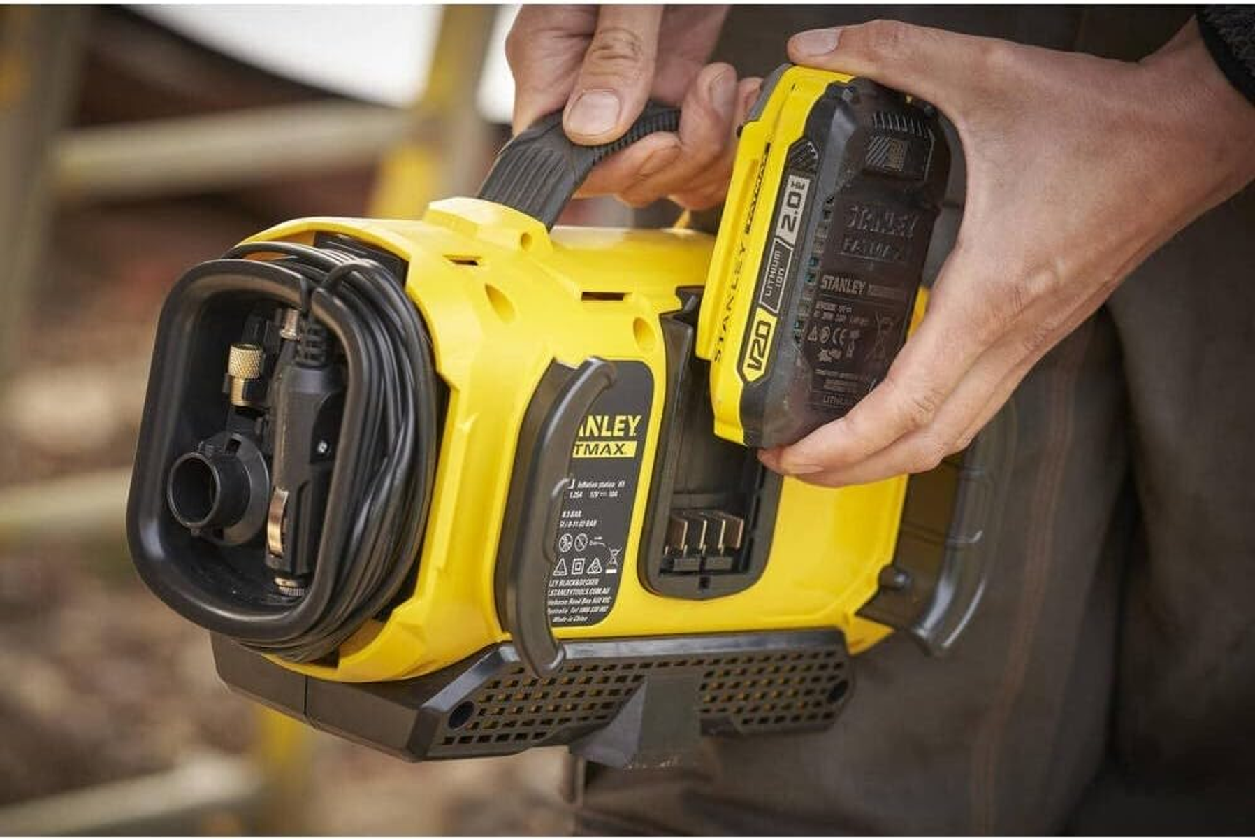 Żółta myjka ciśnieniowa Stanley z odłączaną ręcznie baterią.