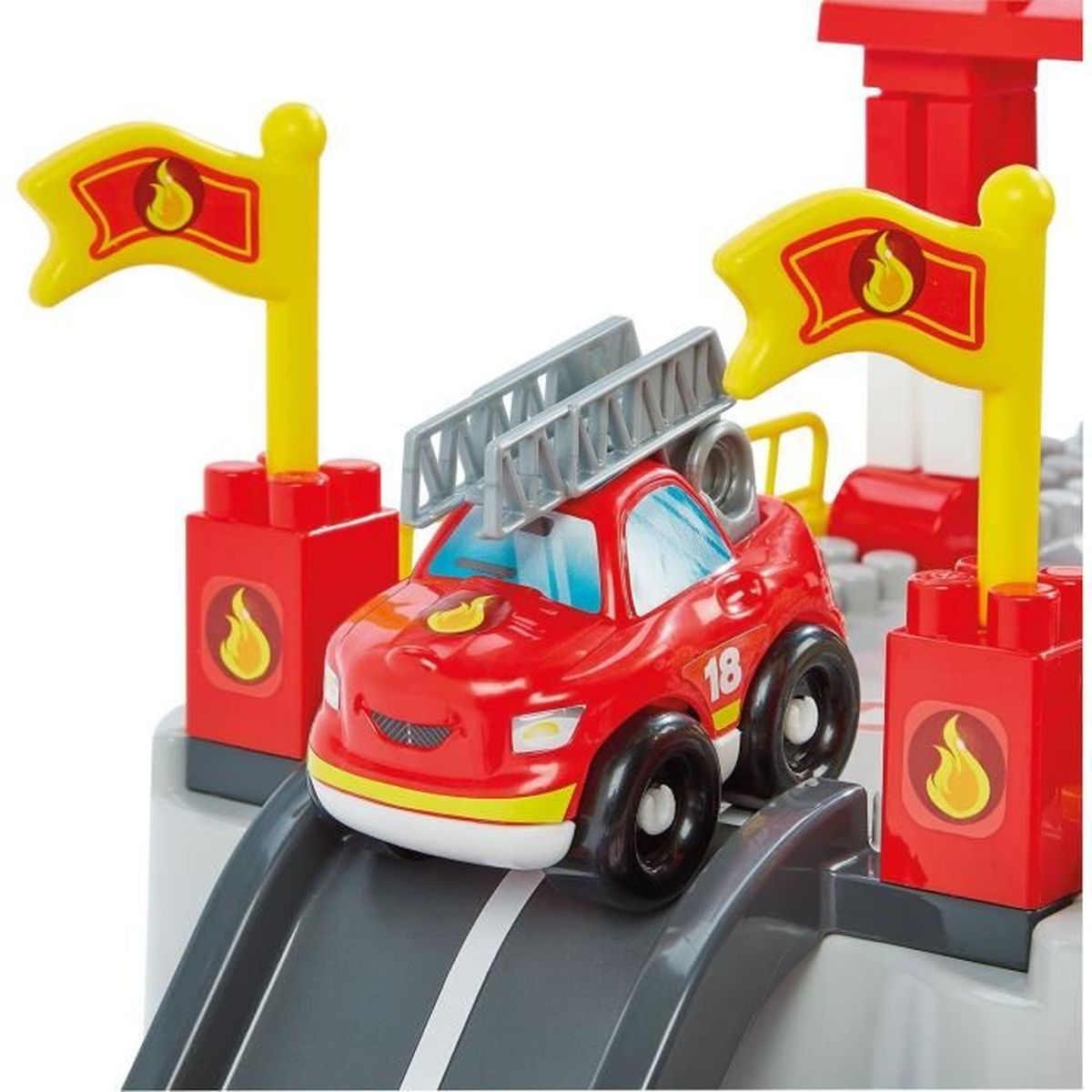 Ein rotes Spielzeug-Feuerwehrauto mit Leiter steht auf einer grauen Rampe neben roten Blöcken mit Flaggen.
