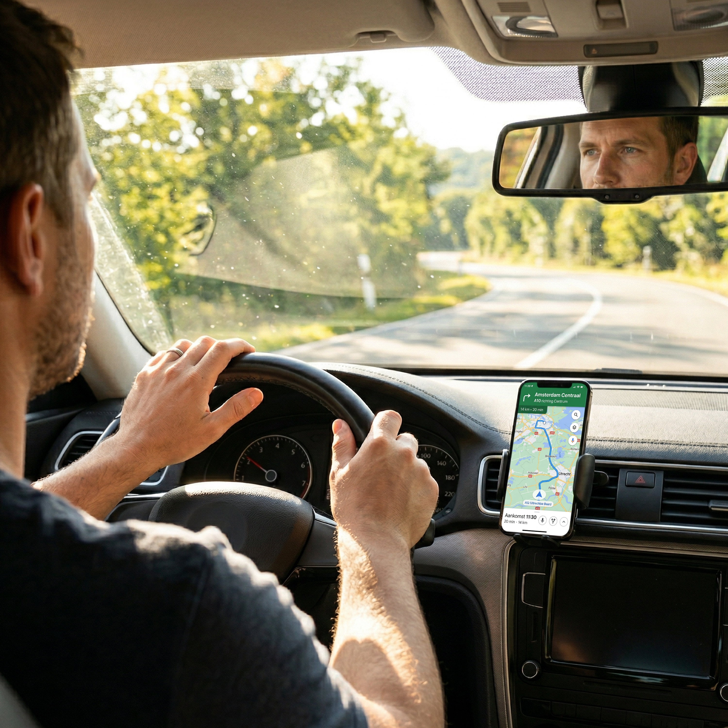 Man rijdt auto, telefoon met navigatie op ventilatierooster, kijkt in achteruitkijkspiegel.