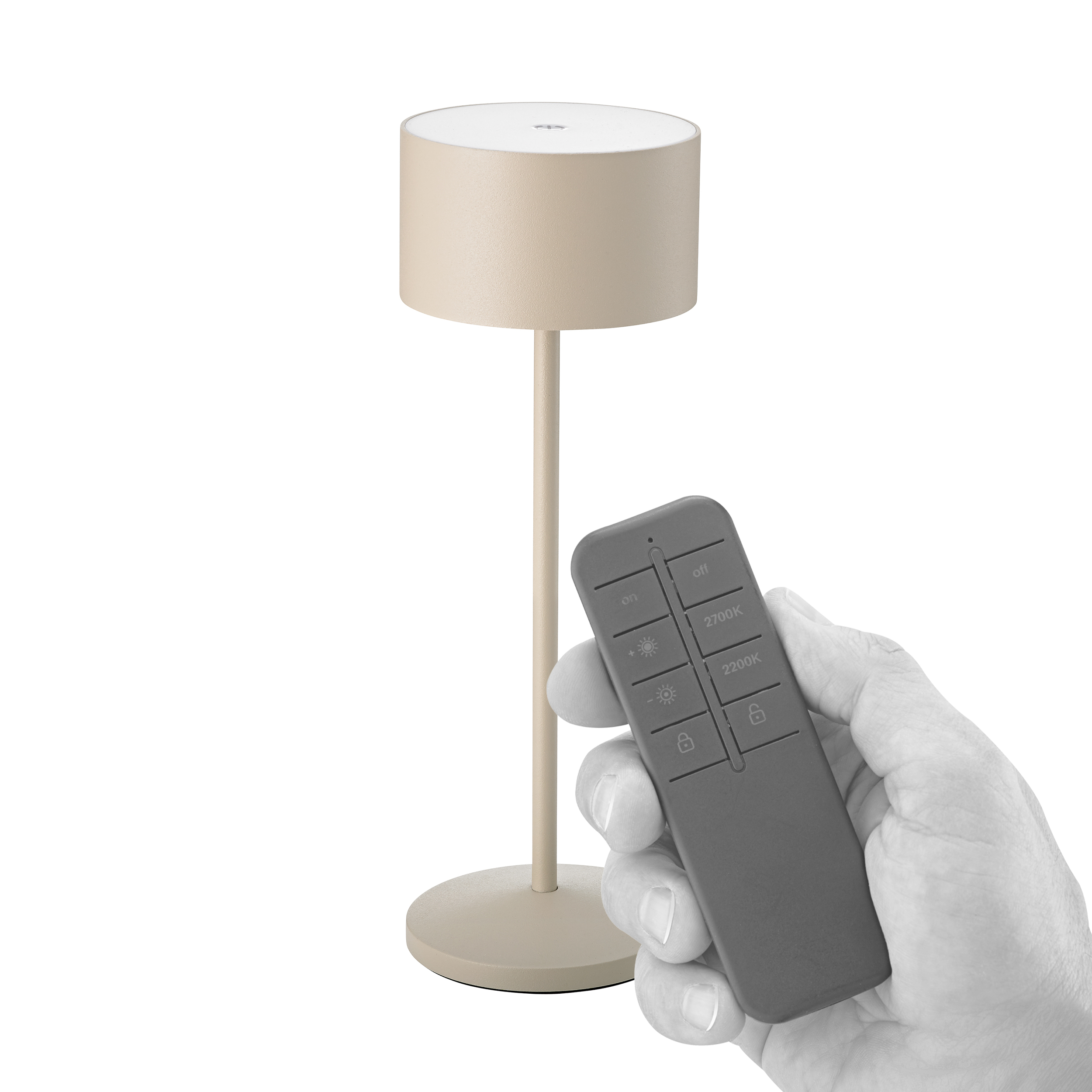 Eine Hand hält eine Fernbedienung neben einer beigefarbenen Lampe.