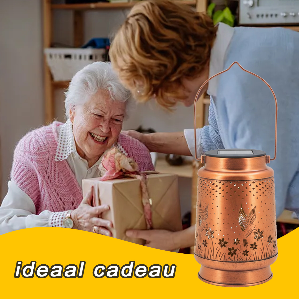 Eine ältere Frau lächelt, als sie ein Geschenk von einer anderen Frau erhält. Eine SolarLaterne ist im Vordergrund.
