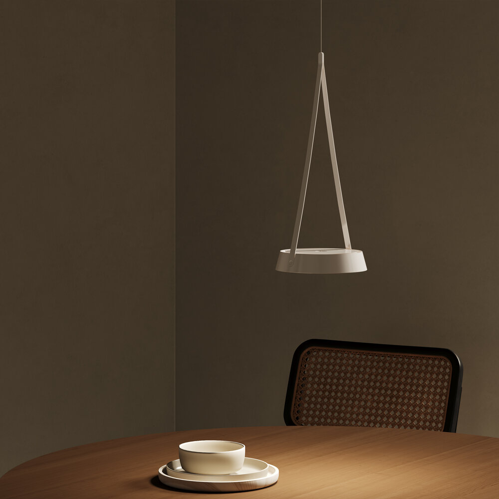 Ein weißer Hängelampen über einem Holztisch mit Geschirr und einem Rattanstuhl.