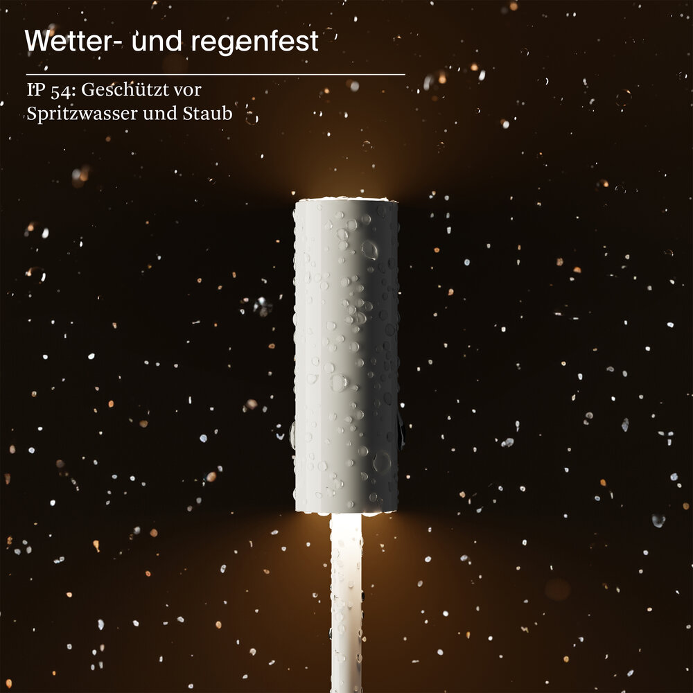 Eine weiße Lampe mit Wassertropfen im Regen bei Nacht.