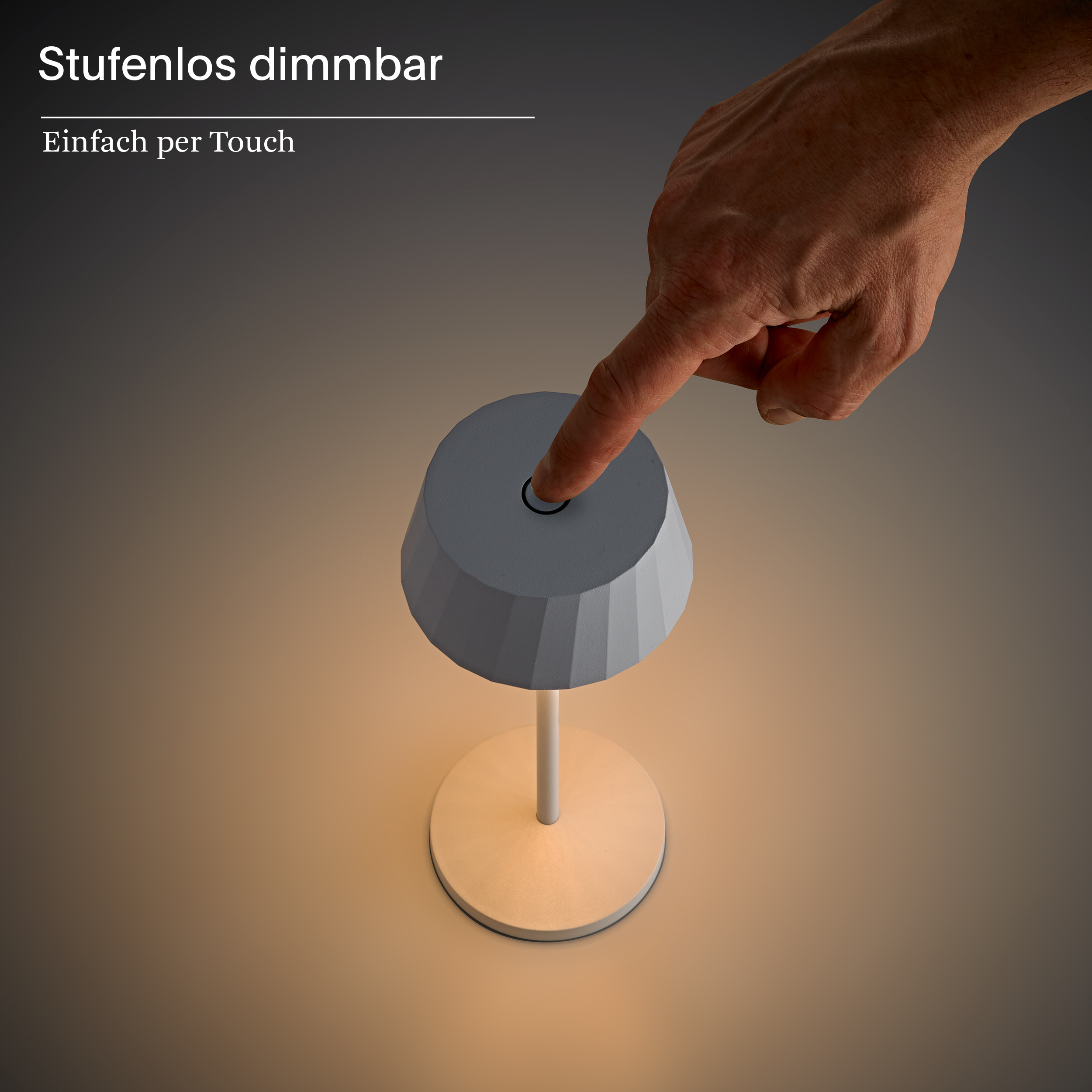Ein Finger berührt eine weiße Lampe mit gestuftem Lampenschirm und beleuchtetem Sockel.