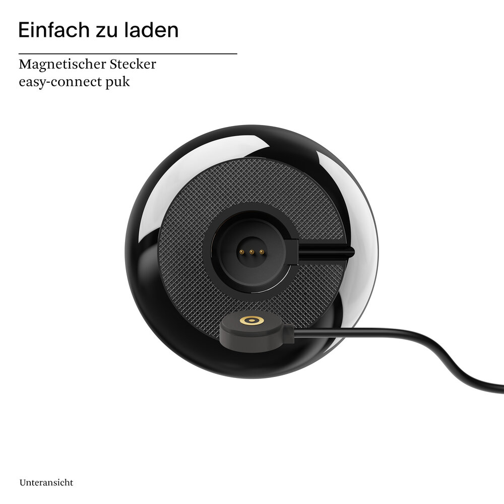 Ein schwarzer magnetischer Ladeadapter mit goldenem Kreis auf einem Gittermuster-Hintergrund.