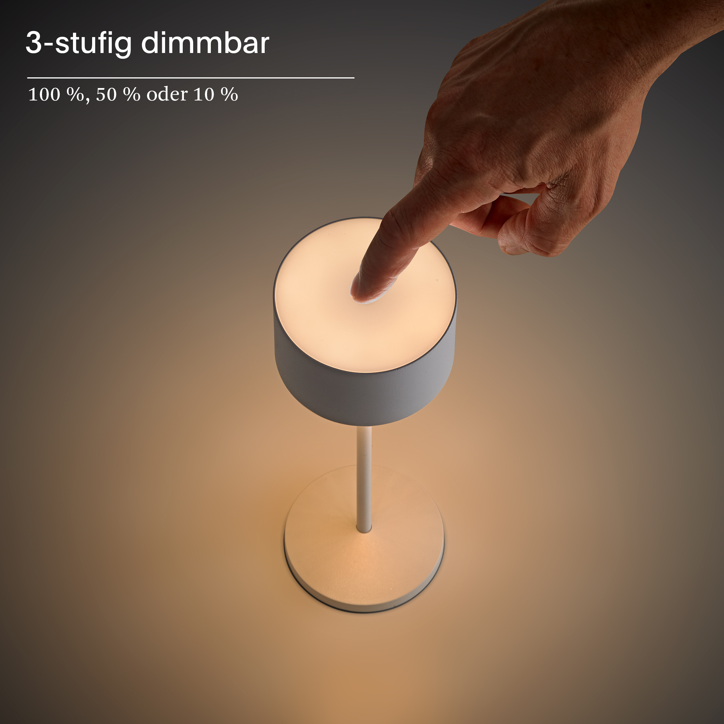 Eine Hand berührt eine weiße Lampe mit drei Helligkeitsstufen.