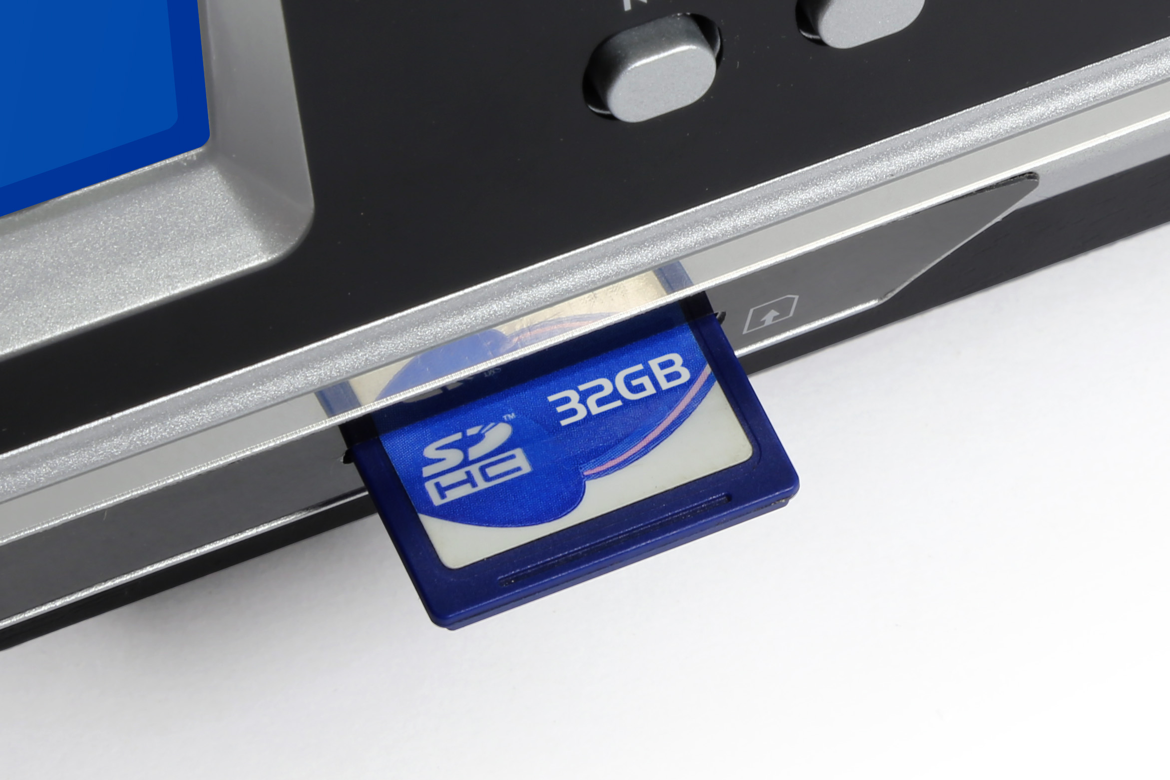 Una tarjeta de memoria SDHC azul de 32GB insertada en una ranura.