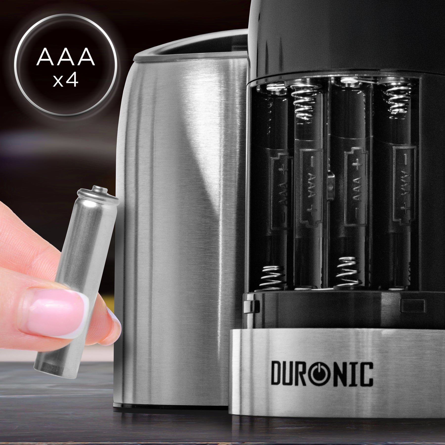 Eine Hand setzt eine AAA-Batterie in ein Duronic-Gerät mit vier Batteriefächern ein.