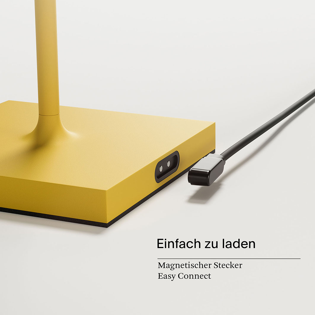Gelbe Basis mit einem magnetischen Ladekabel in einer Buchse.