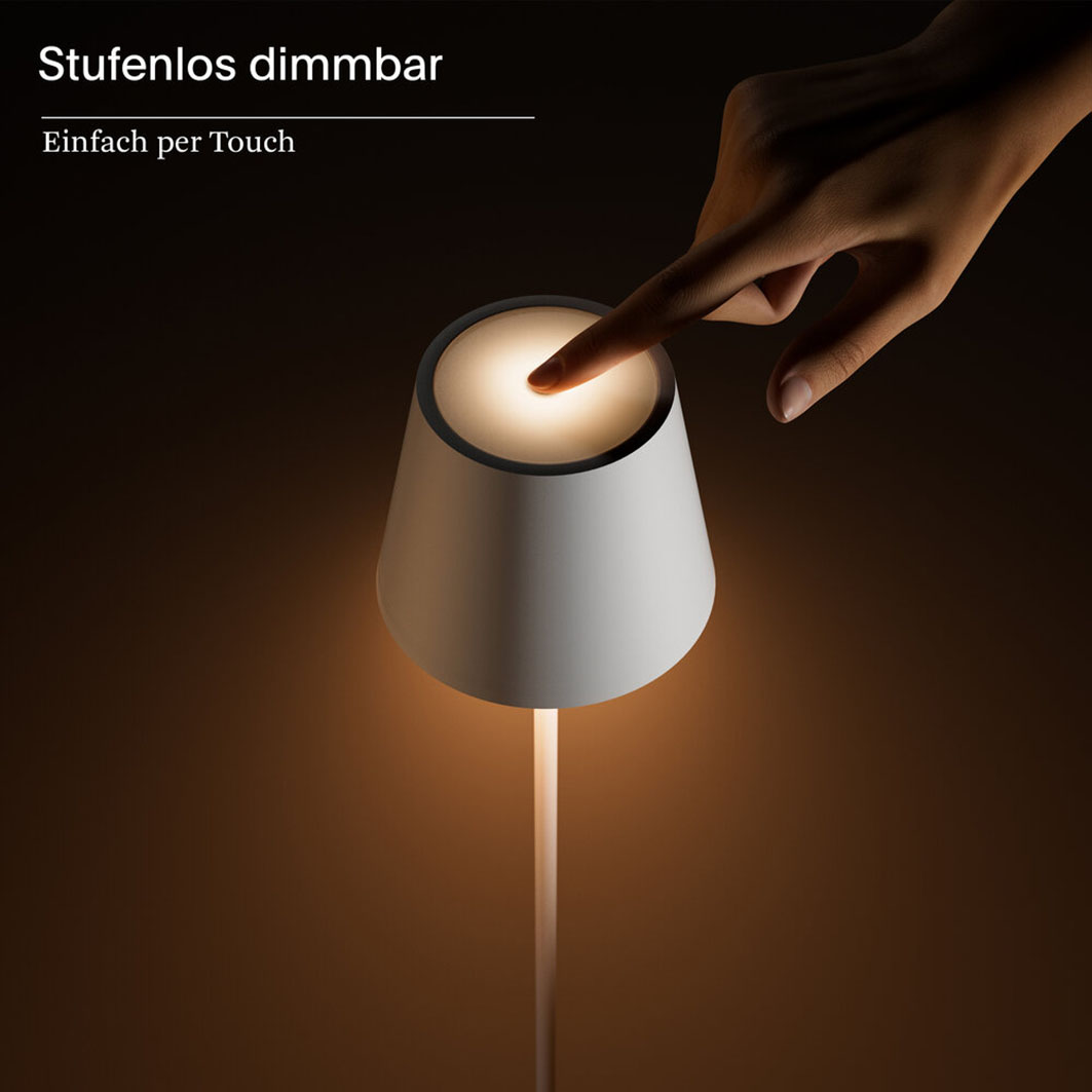 Eine Hand berührt eine weiße Nachttischlampe, die Licht spendet.