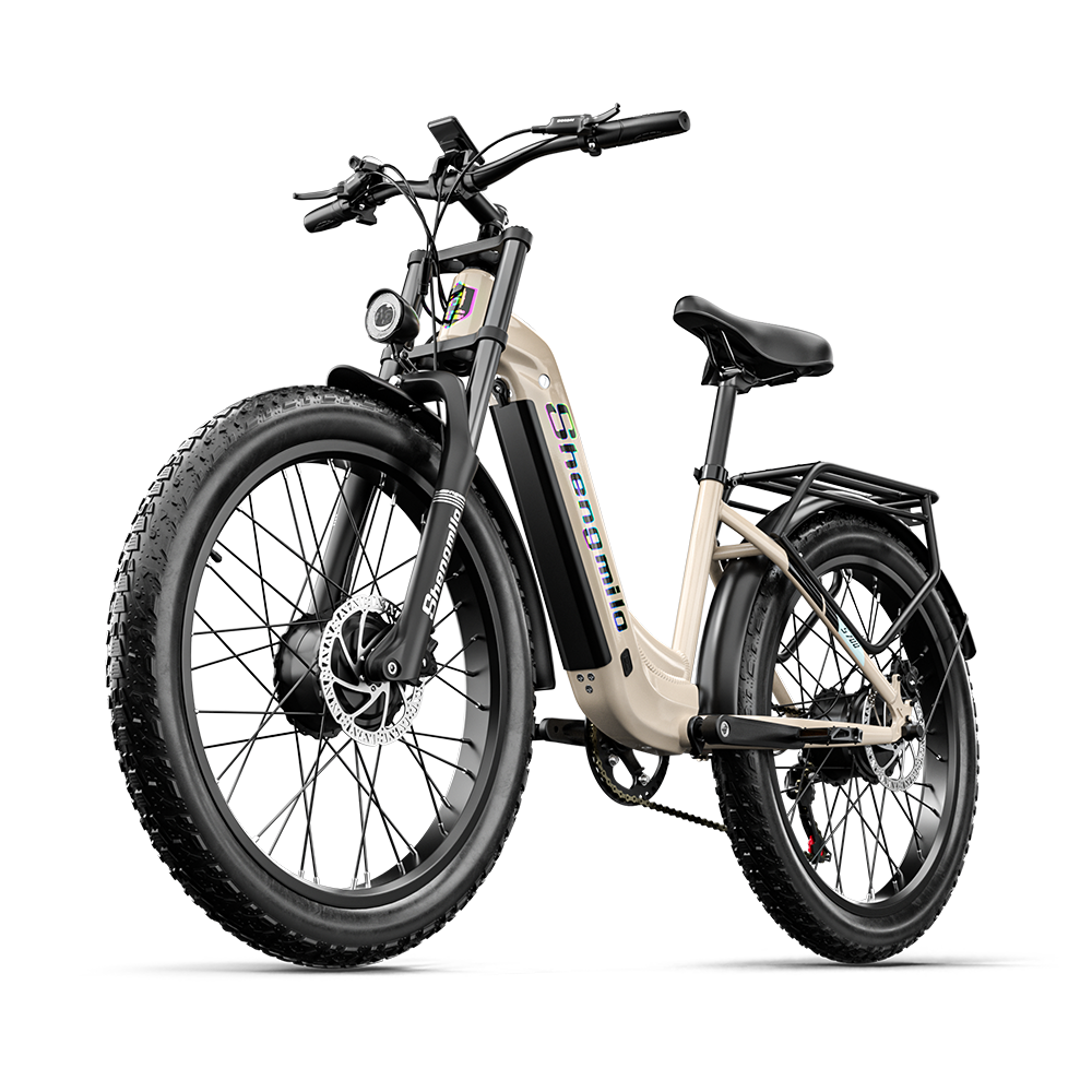 Ein beiges E-Bike mit dicken Reifen, schwarzem Gepäckträger und Scheinwerfer.