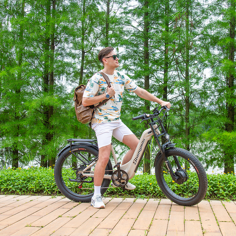 Mann auf E-Bike vor Bäumen.