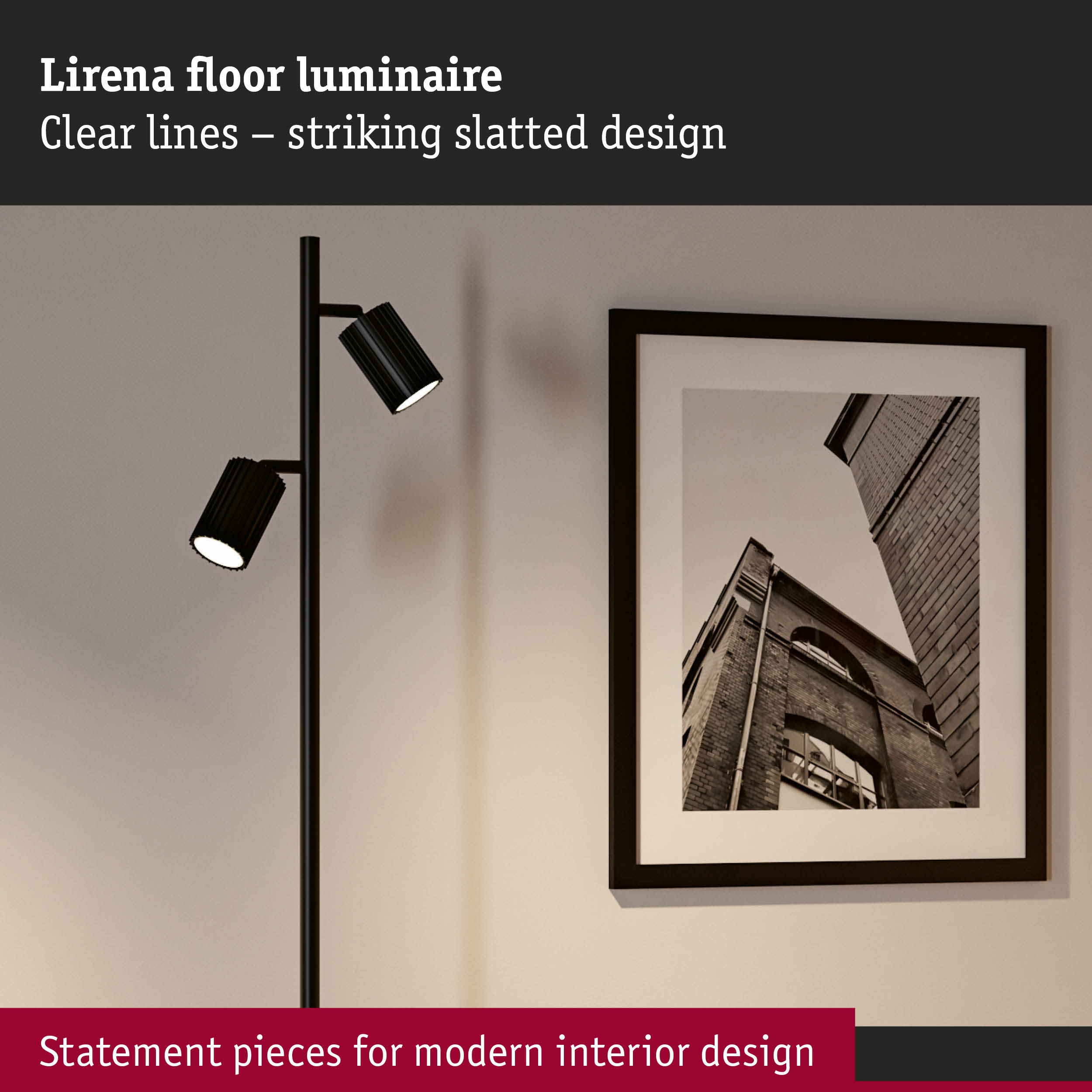 Un bras de lampadaire noir avec deux spots réglables à côté d'un tableau encadré.