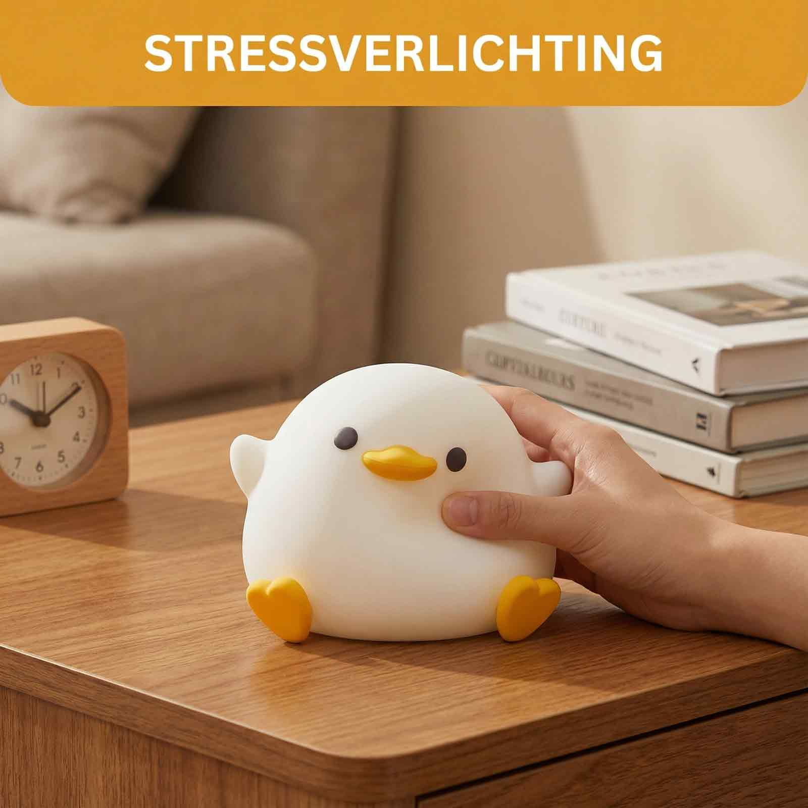 Eine weiße Entenlampe mit gelbem Schnabel und Füßen sitzt auf einem Holztisch.