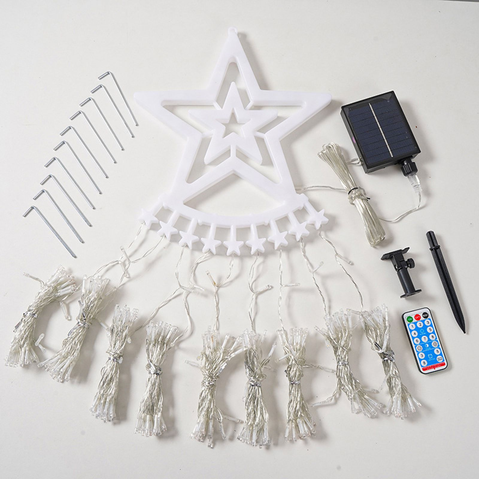 Ein weißer Stern-Lichterketten-Set mit Solarpanel, Fernbedienung und Erdspießen.