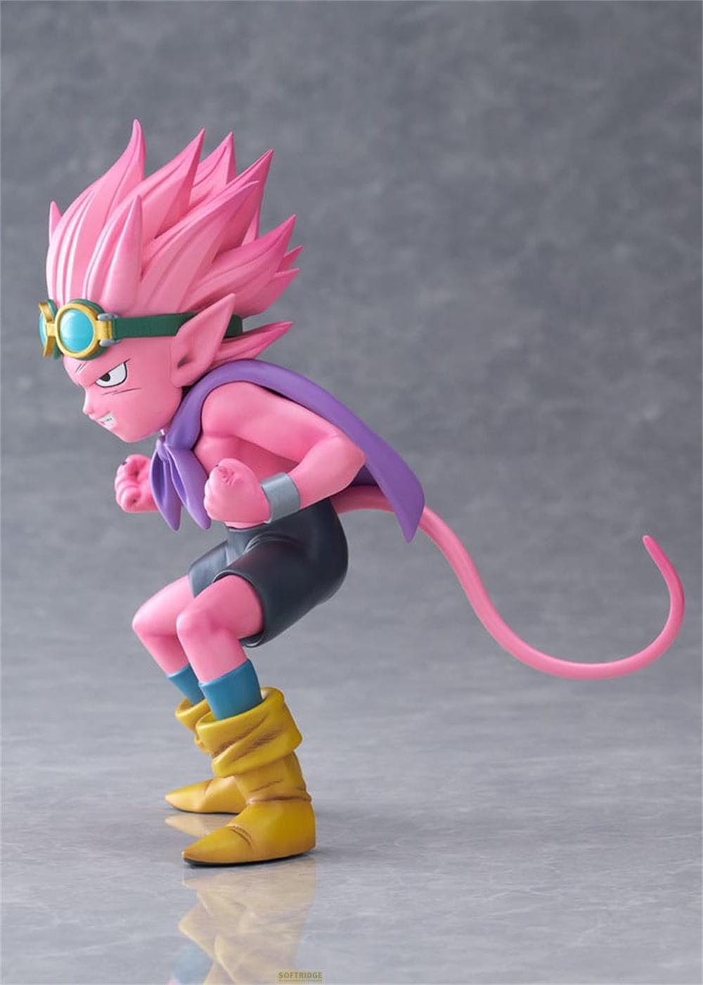 Una figura rosa con botas, pantalones cortos, capa y gafas.