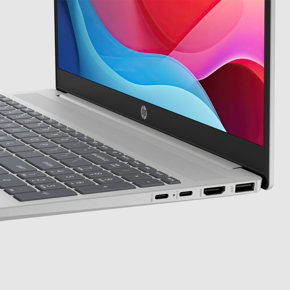 Srebrny laptop z klawiaturą i portami. Ekran wyświetla kolorowe kształty abstrakcyjne.