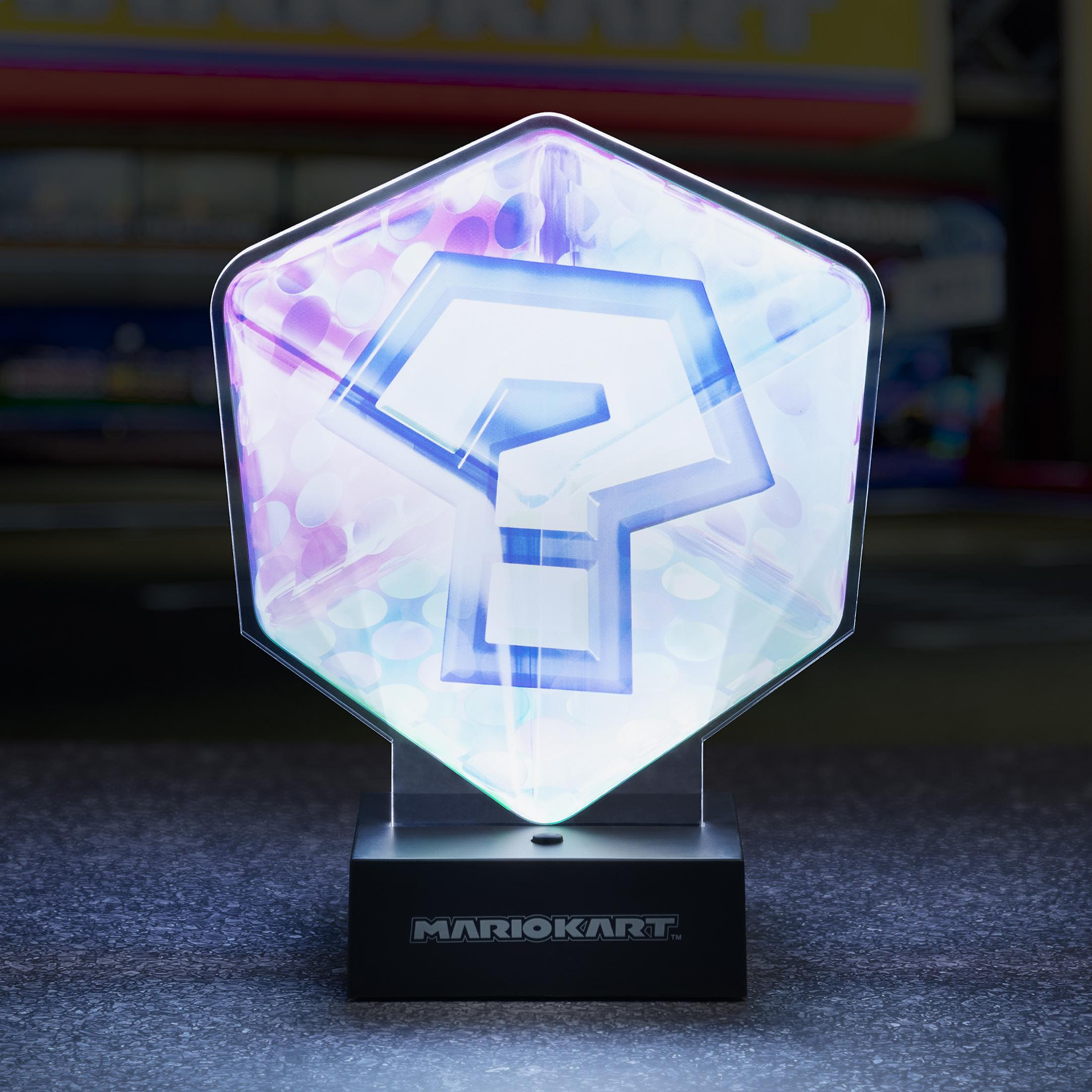 Ein leuchtender Mario Kart Fragezeichen-Block auf einem Ständer mit 'MARIOKART'-Logo.