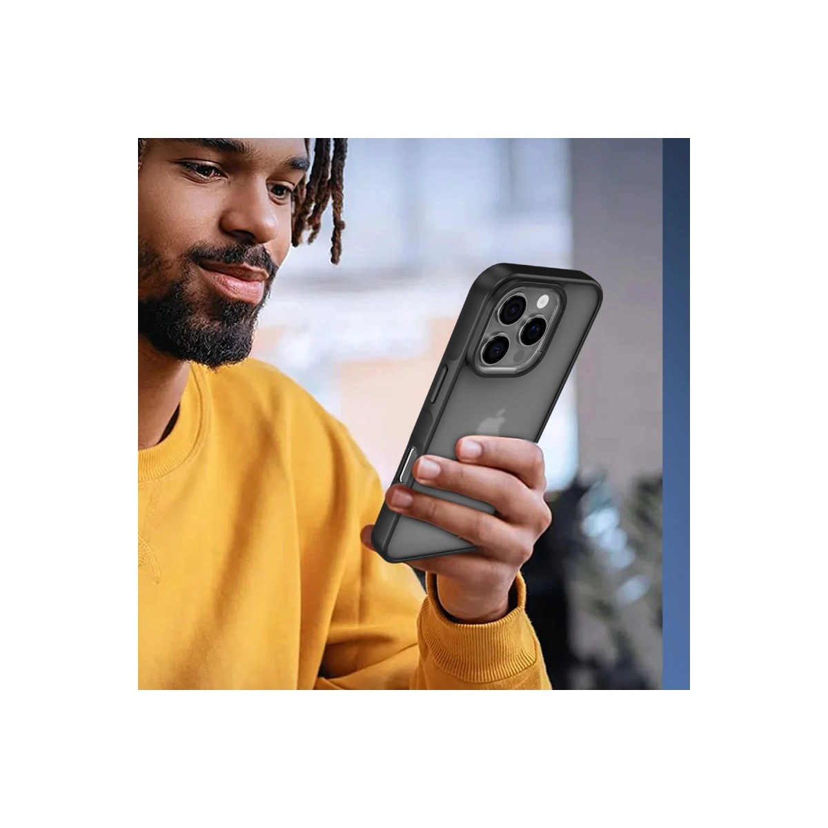 Sarı sweatshirt'li adam siyah kılıflı akıllı telefon tutuyor.